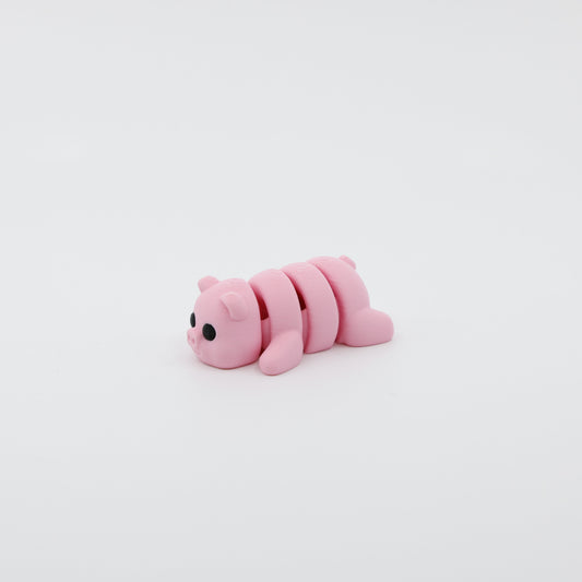 Side profile of articulated pig sensory fidget highlighting smooth body segments and adorable features