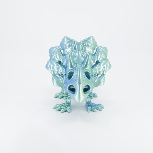 Flexi 3D printed dinosaur skeleton Triceratops shown from the front. Highlights the large frill, three horns, and articulated legs.