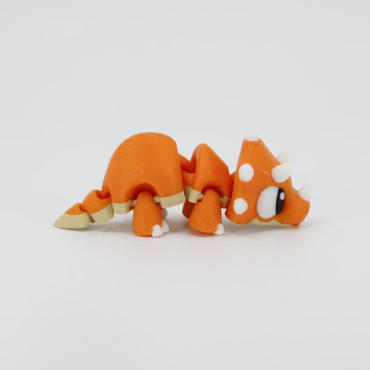 Side view of the flexible 3D printed Triceratops Wiggle Bud. Shows the textured head shield, horns, and the articulation points along the spine for a subtle wiggle action.