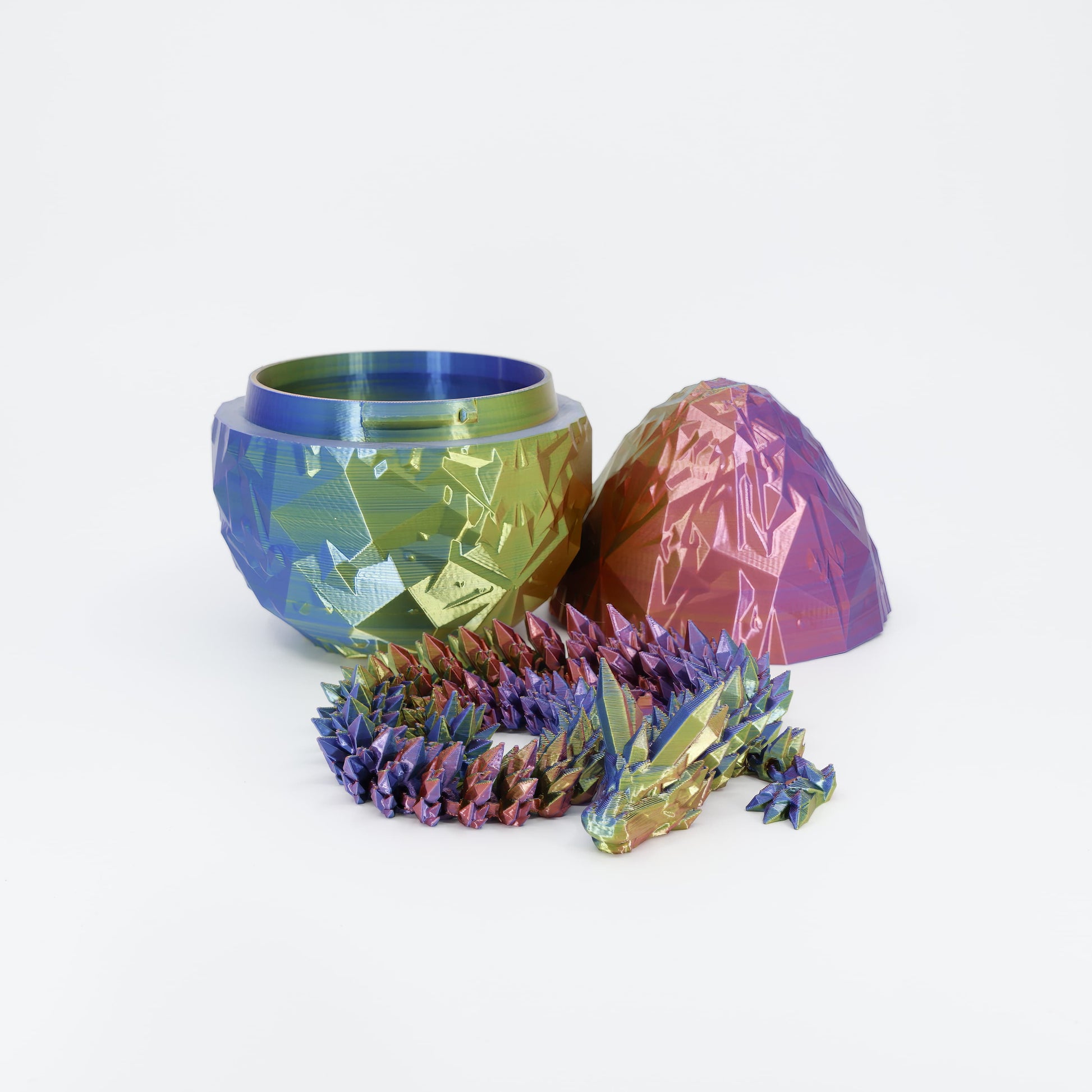 A fully articulated 3D printed dragon toy posed in front of its matching, scale-textured dragon egg. Highlights the detailed design of this fantasy sensory set.