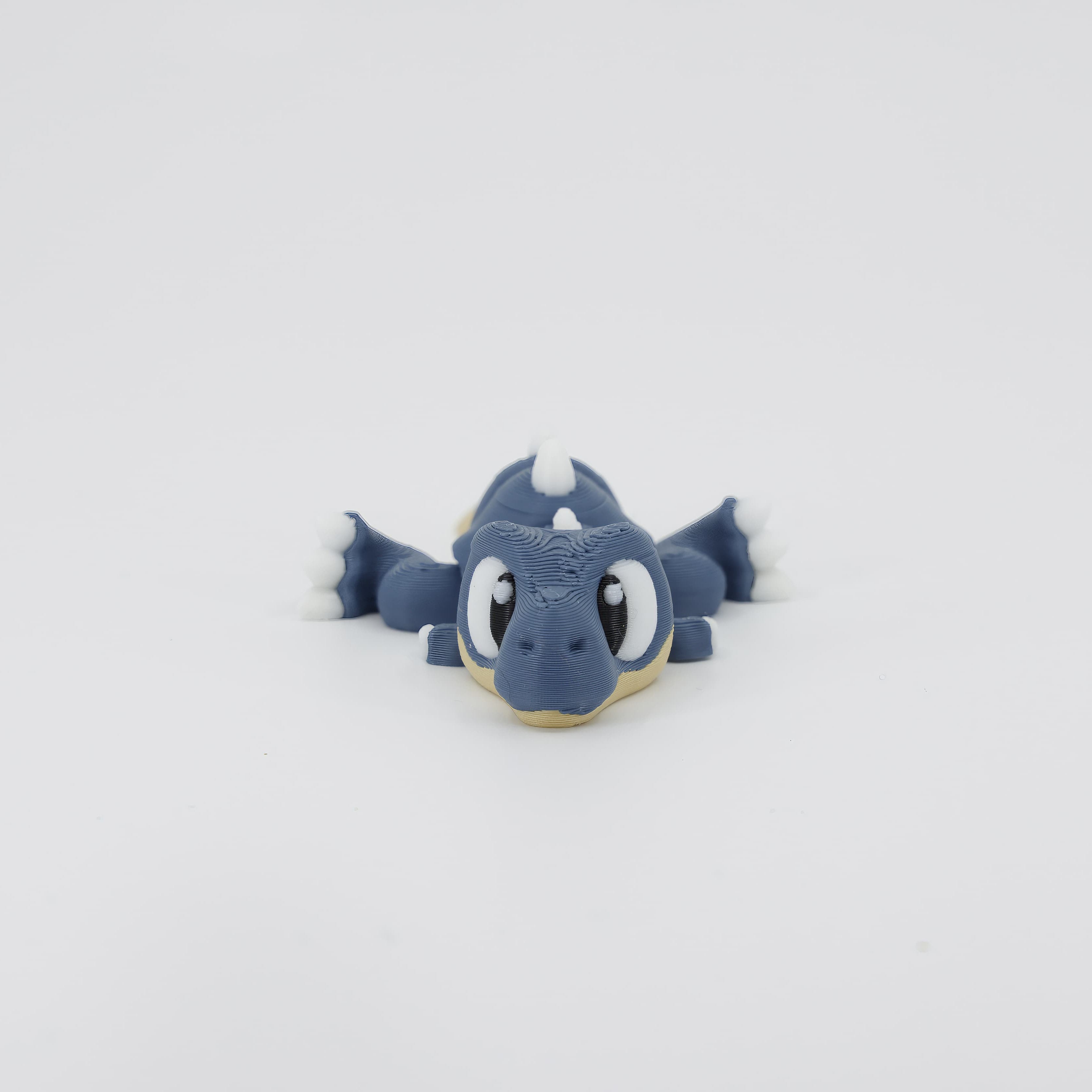 3D printed T-Rex Wiggle Bud flexible toy shown from the front. This popular articulated dinosaur toy features segmented joints and a fun design.