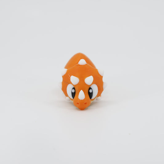 3D printed Triceratops Wiggle Bud flexible toy shown from the front. Highlights the iconic large frill and three horns, a sturdy articulated dinosaur model.