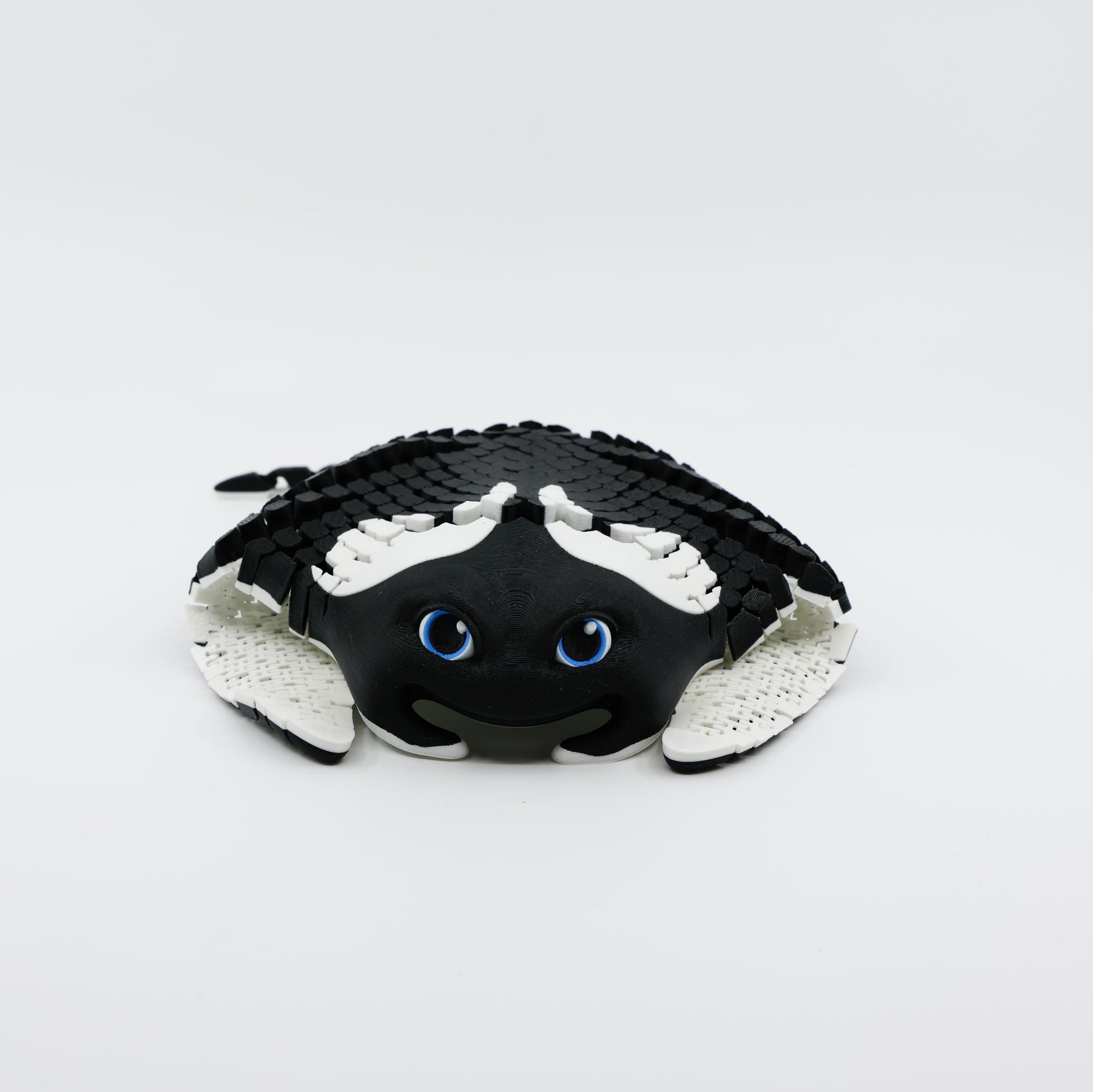 Front view of 3D printed flexible manta ray fidget showing wide wings folded underneath body
