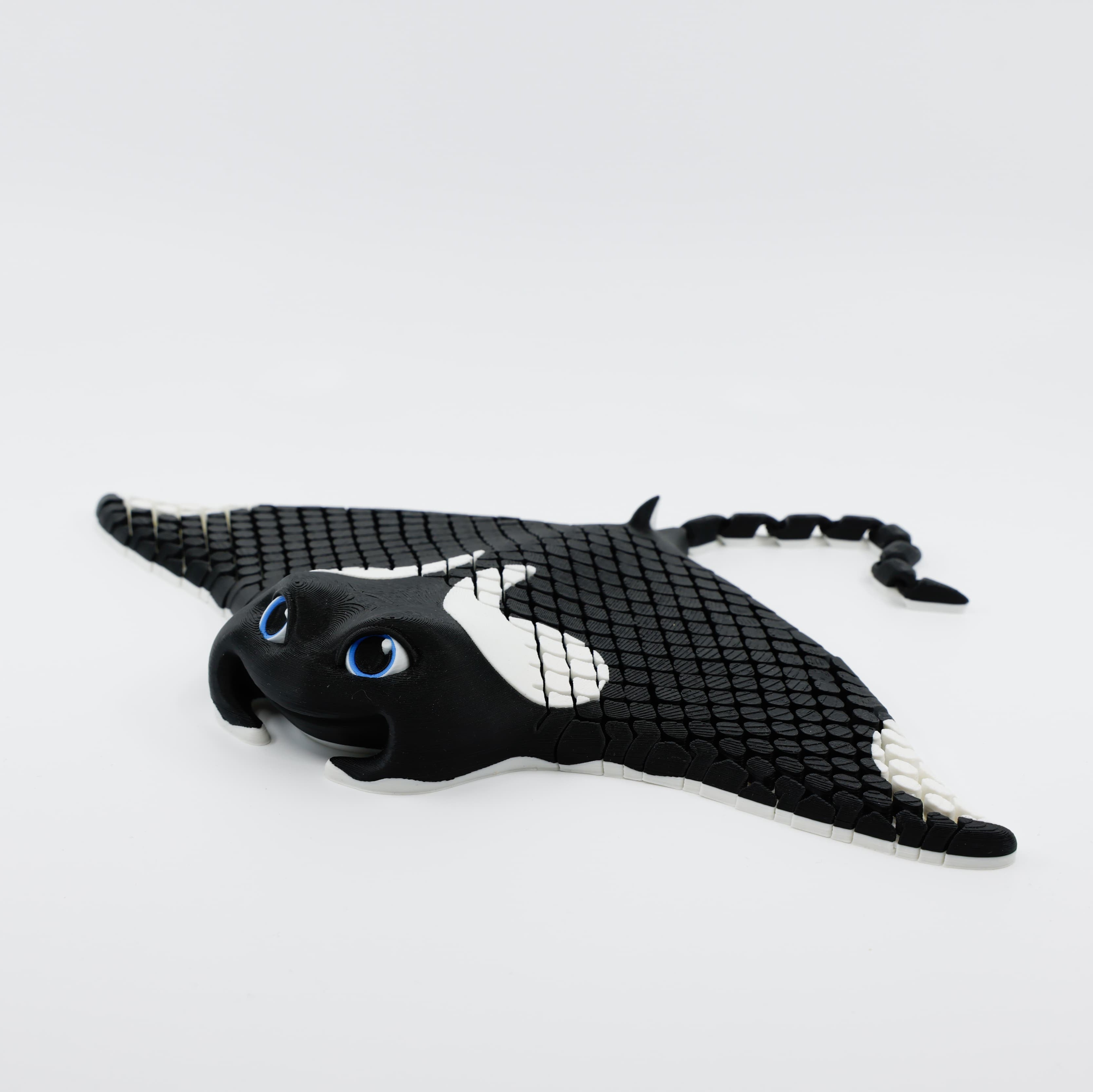 Side profile of 3D printed manta ray fidget highlighting articulated body and curved tail