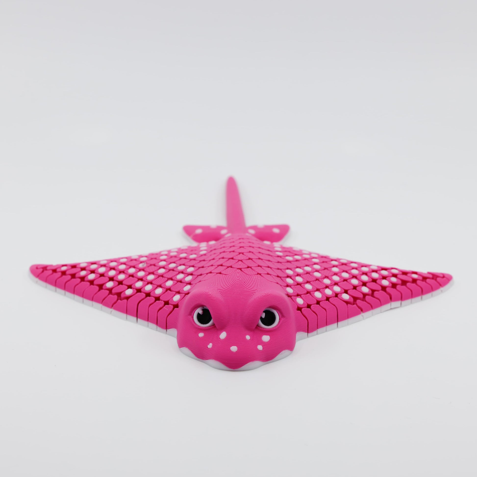 Front view of 3D printed flexible stingray fidget showing detailed facial features and articulated wings in pink