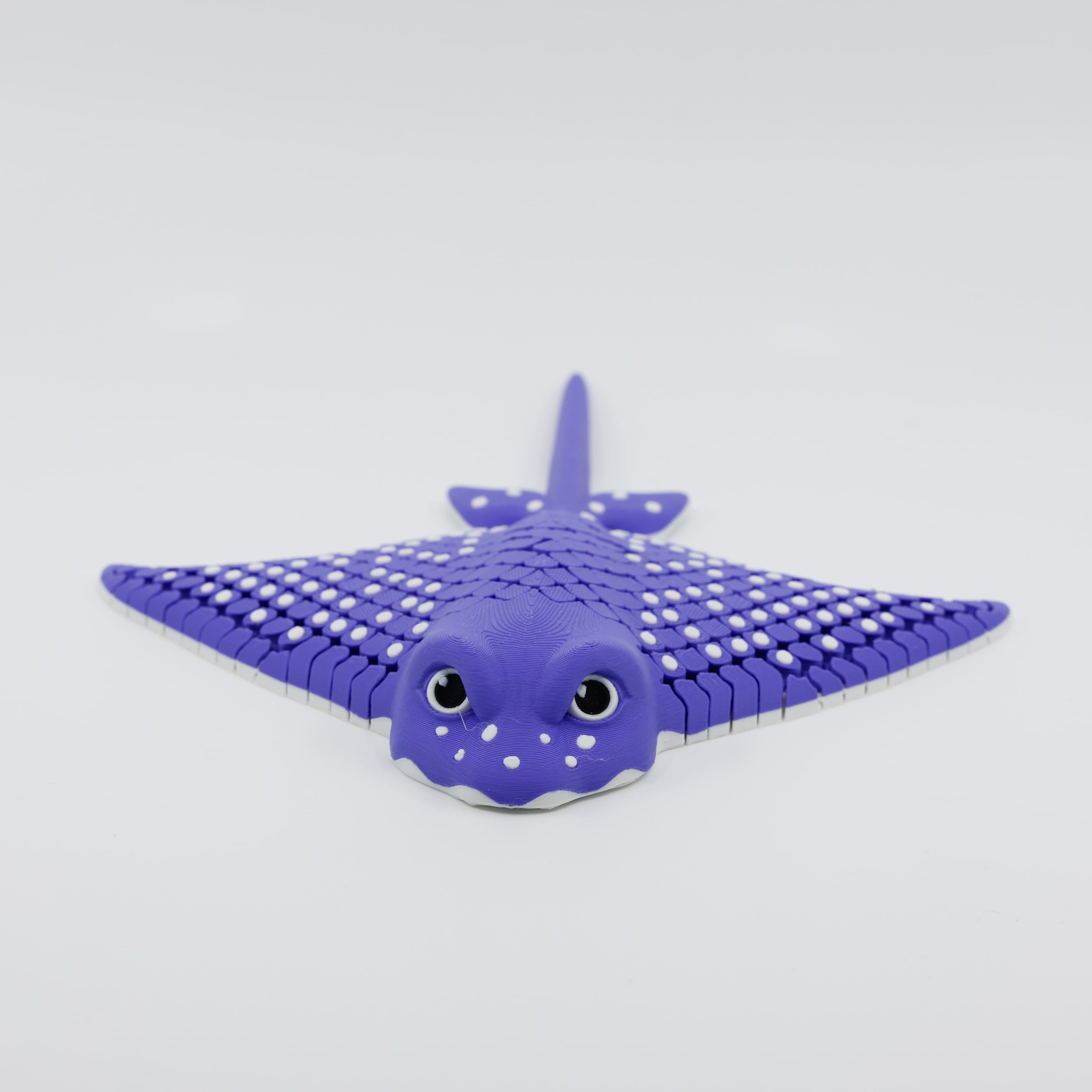 Front view of 3D printed flexible stingray fidget showing detailed facial features and articulated wings in purple