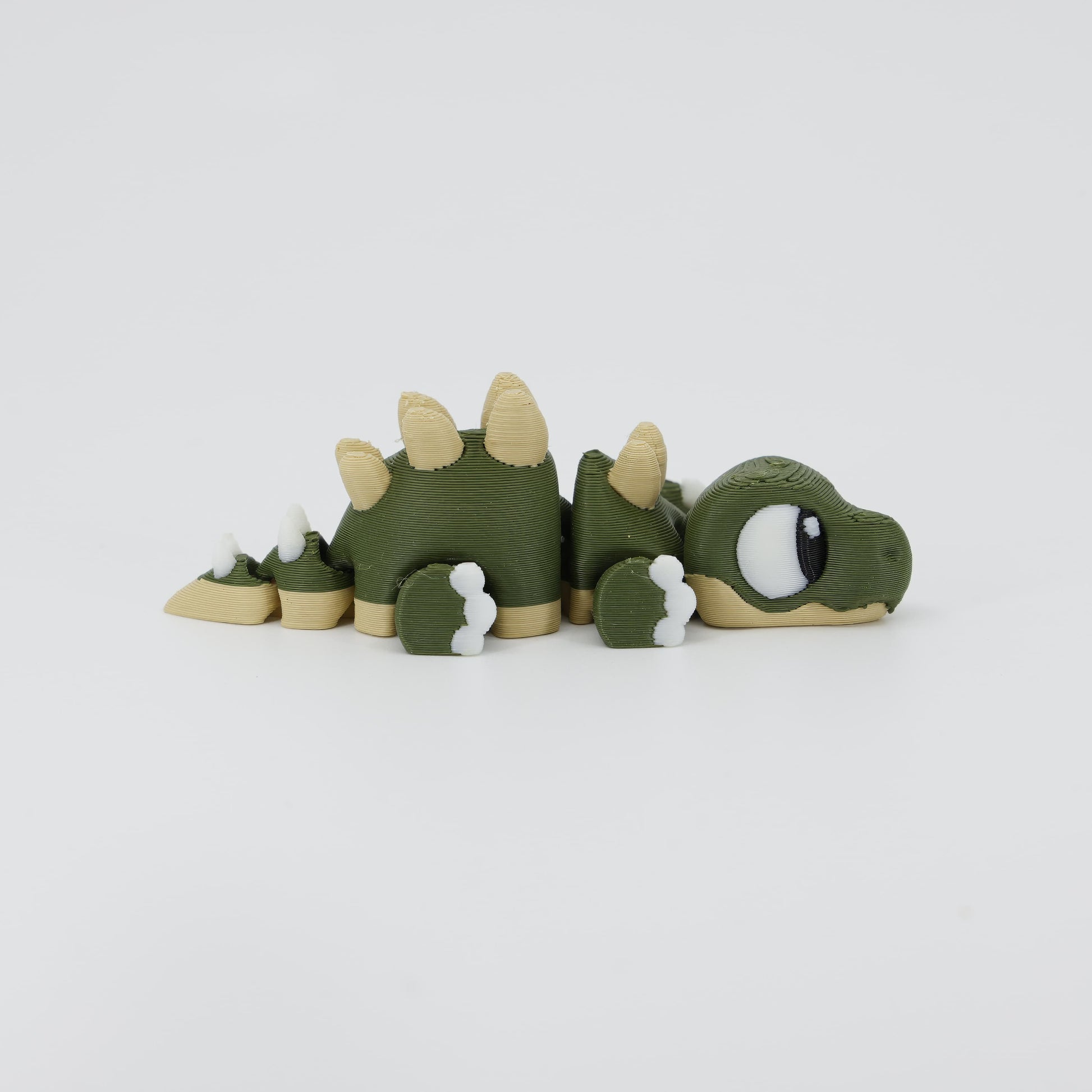 Side profile of the Australian made articulated Stegosaurus fidget, showing the arched back plates and flexi body movement.