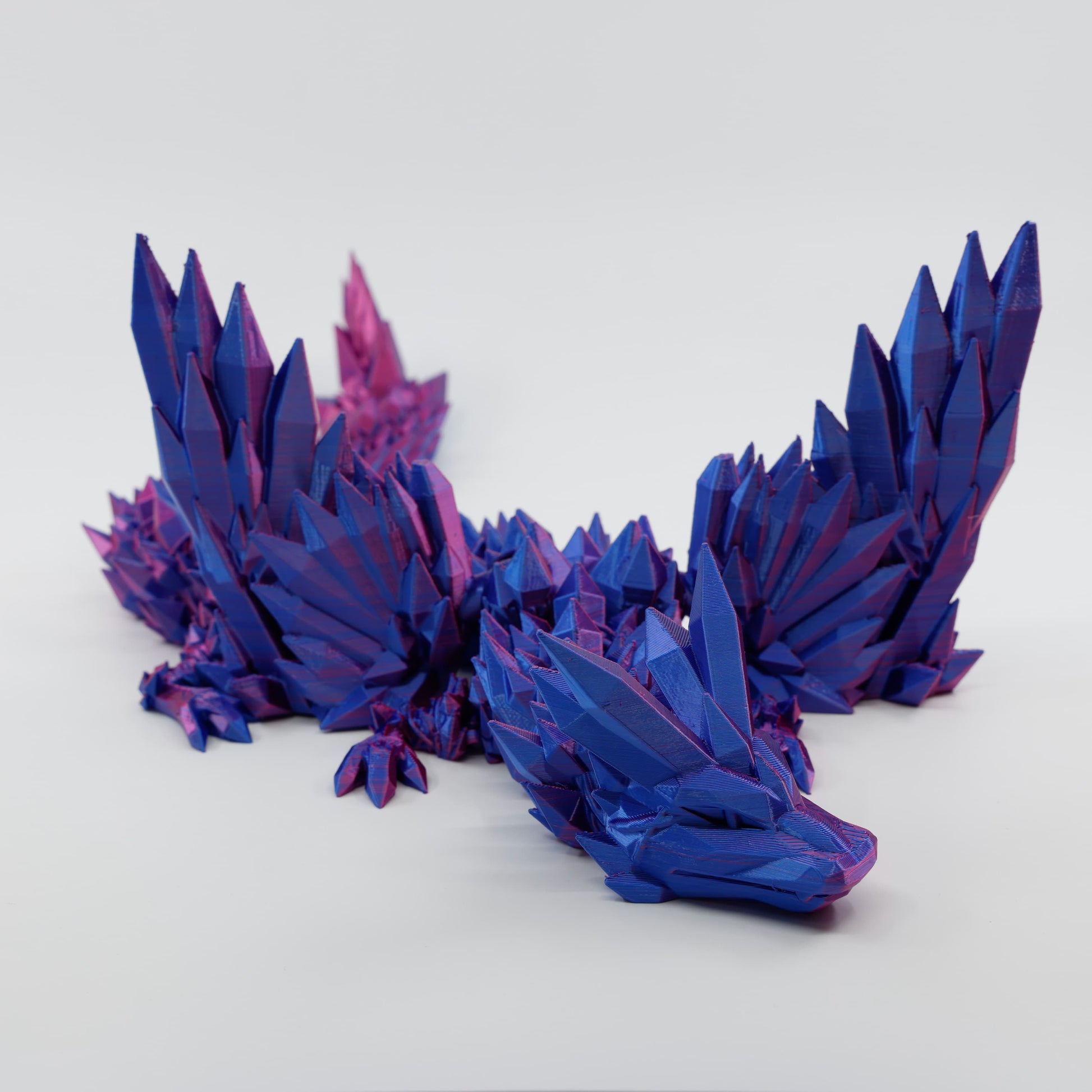 Blue and red articulated winged dragon fidget facing forward with wings spread