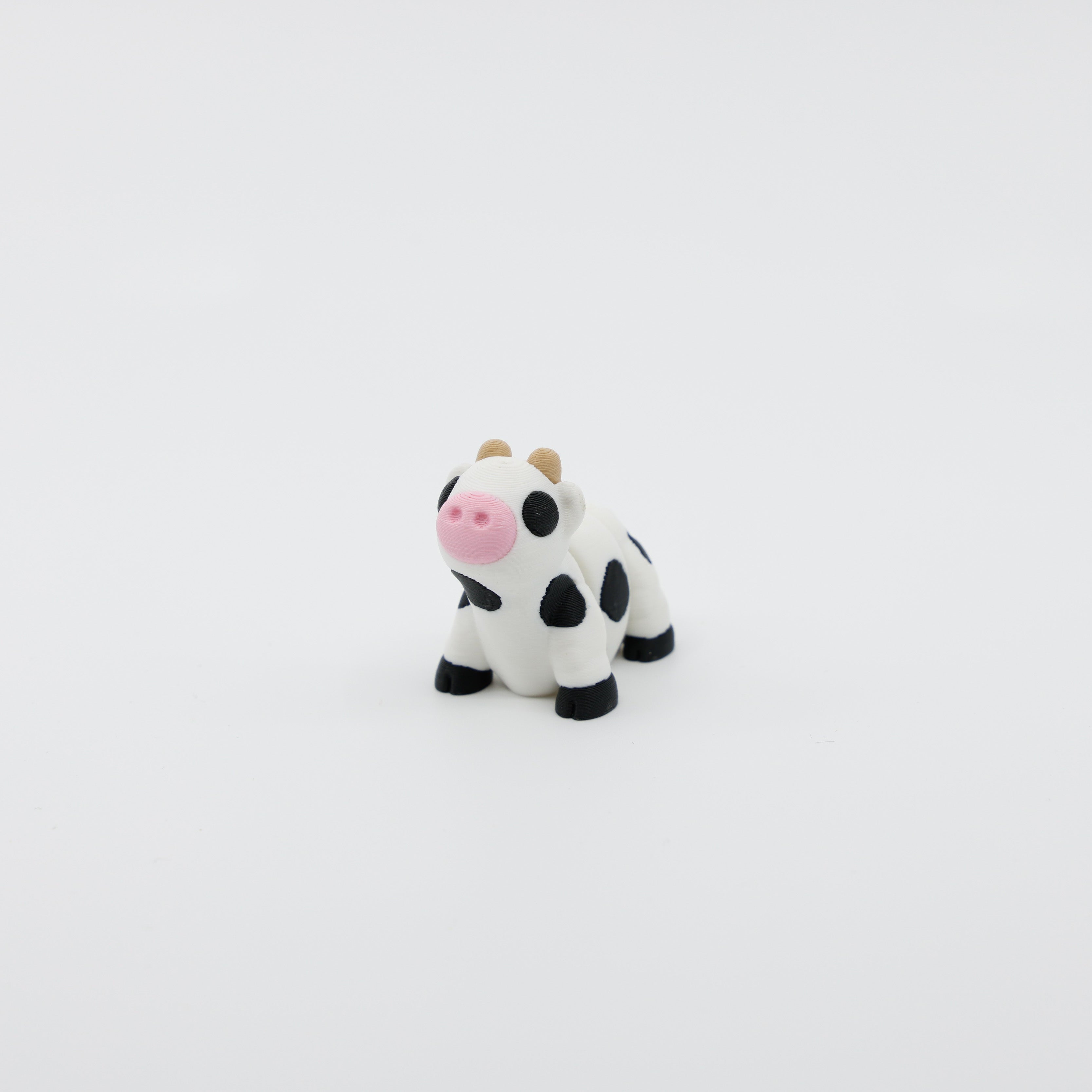 Front view of articulated mini cow sensory fidget with 3D printed face, horns, and detailed features