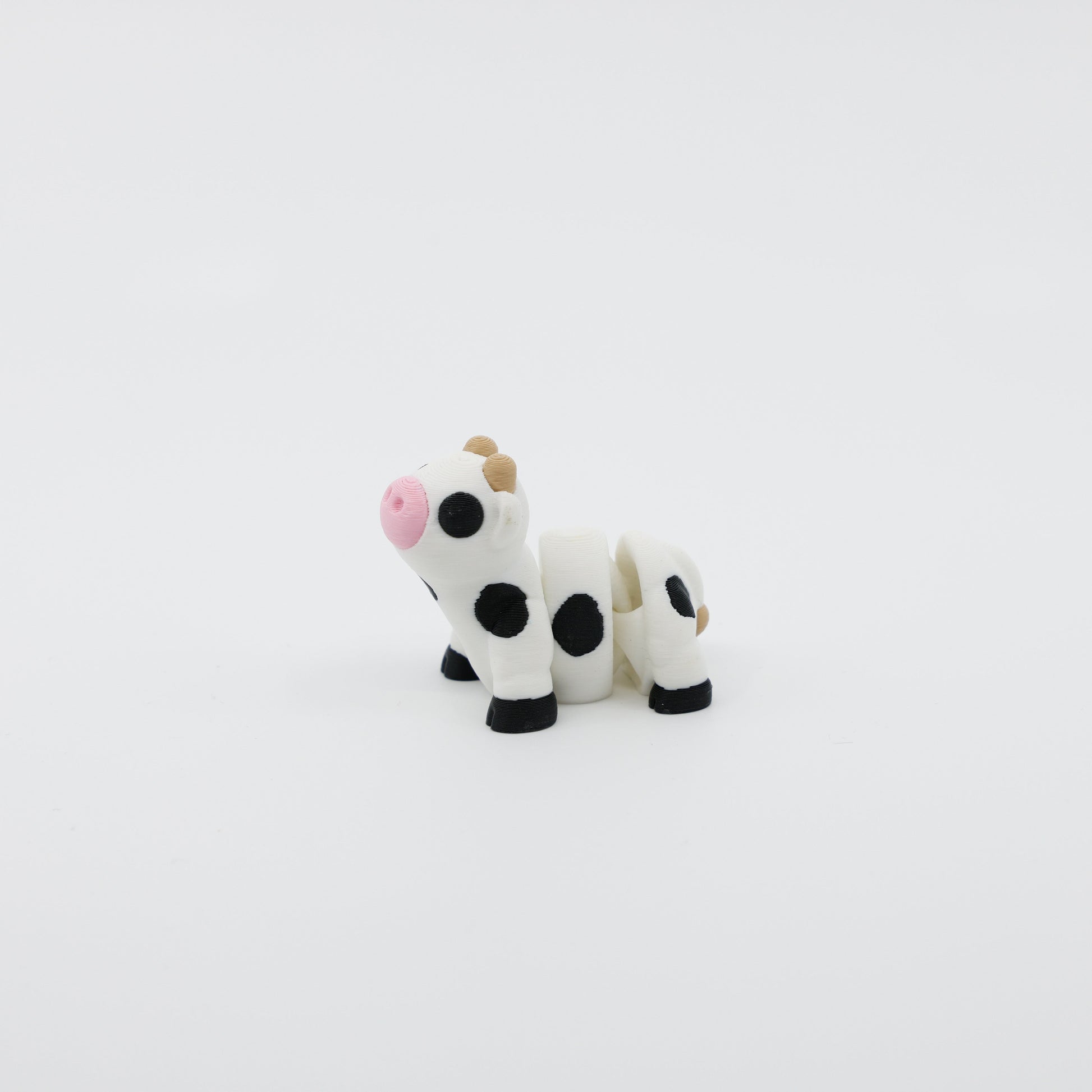 Side profile of articulated cow sensory fidget highlighting body segments and horns