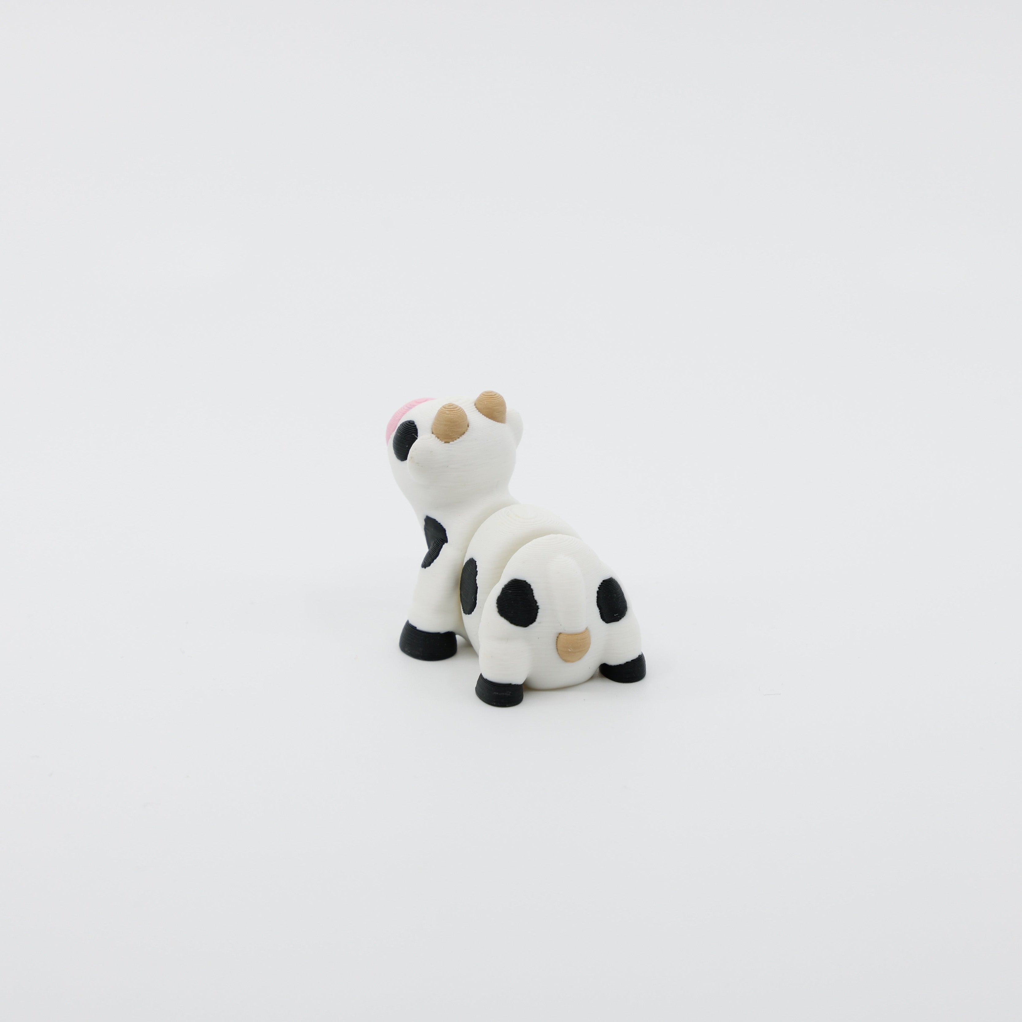 Back view of mini cow fidget showing segmented articulated body and tail design