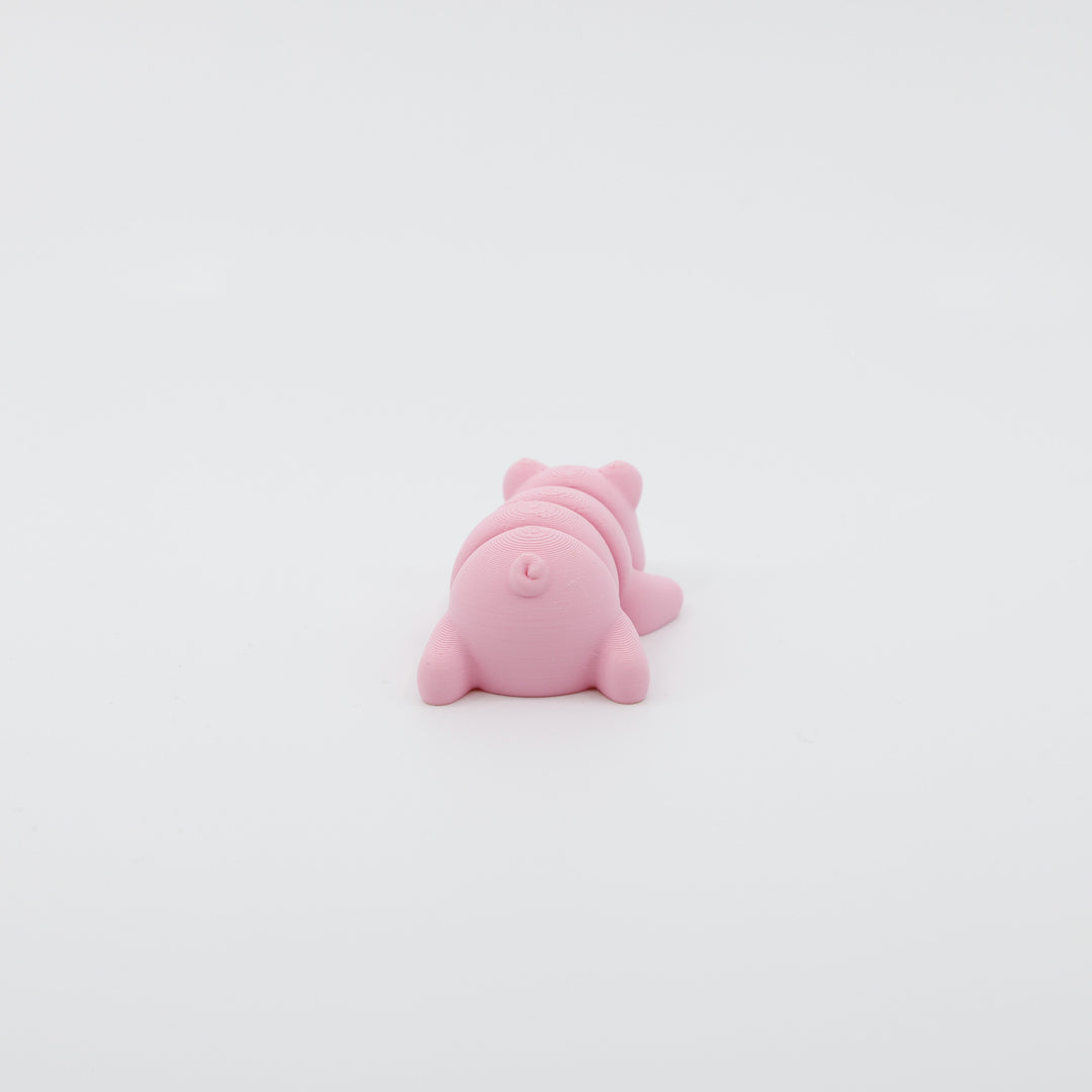 Back view of mini pig fidget showing segmented articulated body and curled tail design