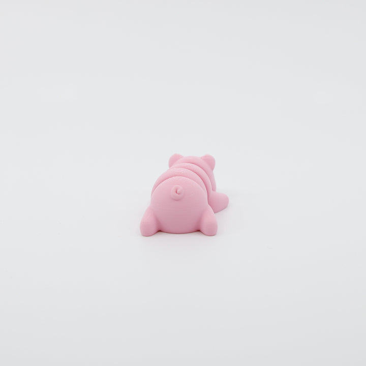 Back view of mini pig fidget showing segmented articulated body and curled tail design