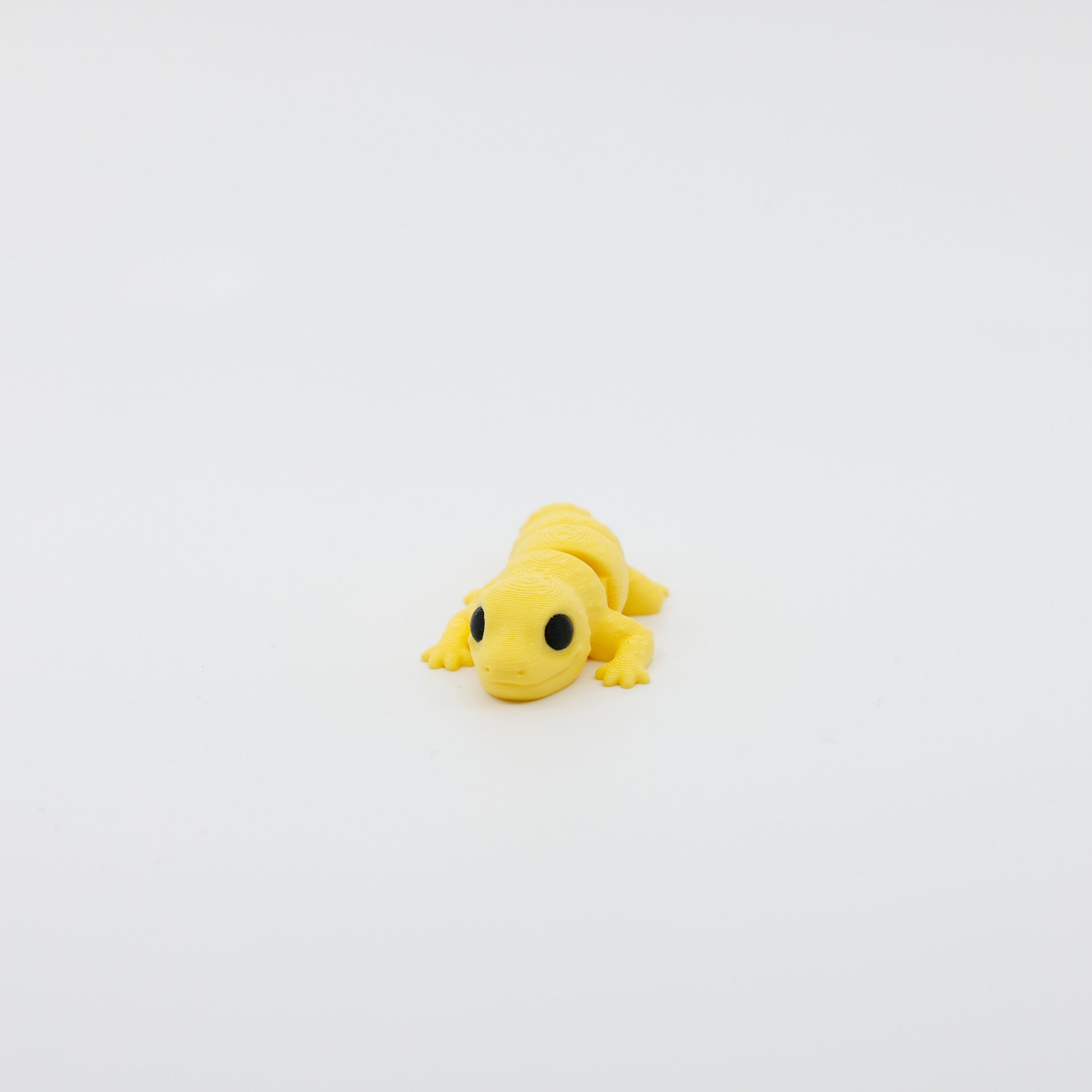 Front view of articulated mini gecko sensory fidget with 3D printed texture and wide-set eyes
