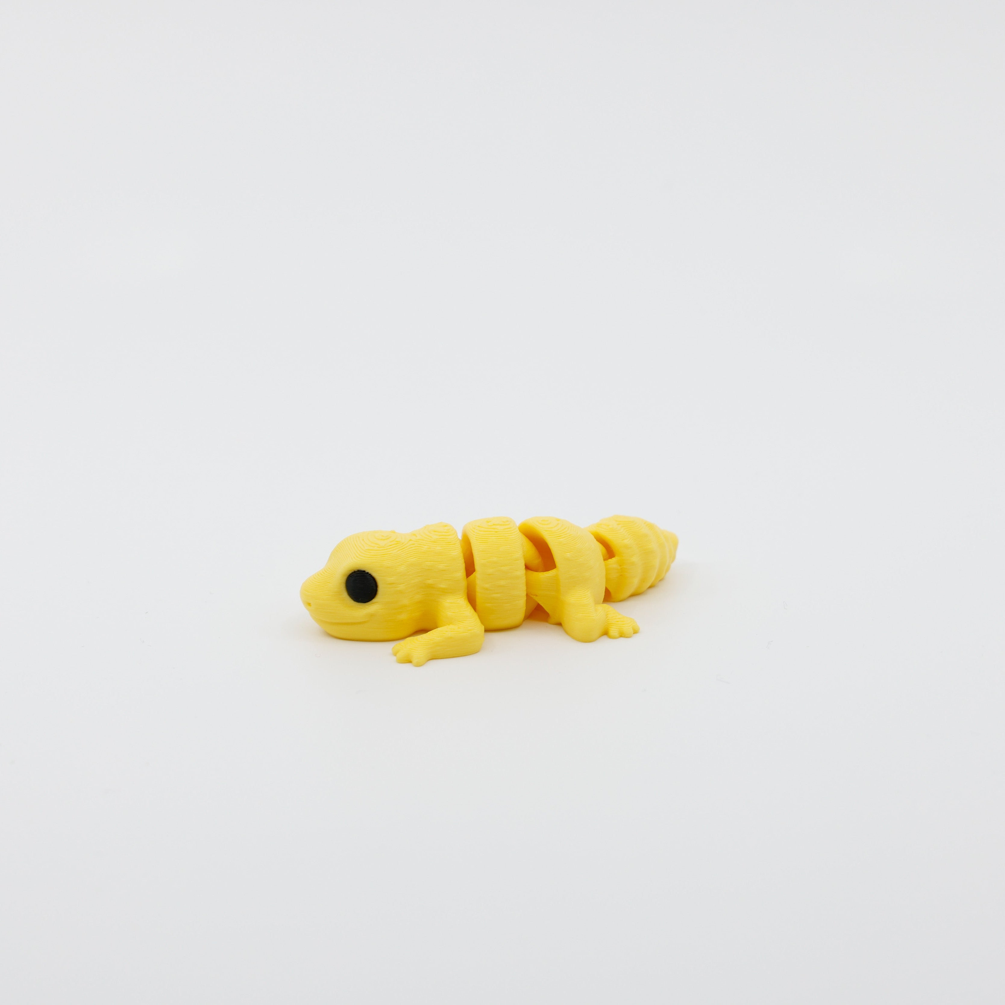 Side profile of articulated gecko sensory fidget with flexible body segments and curved posture
