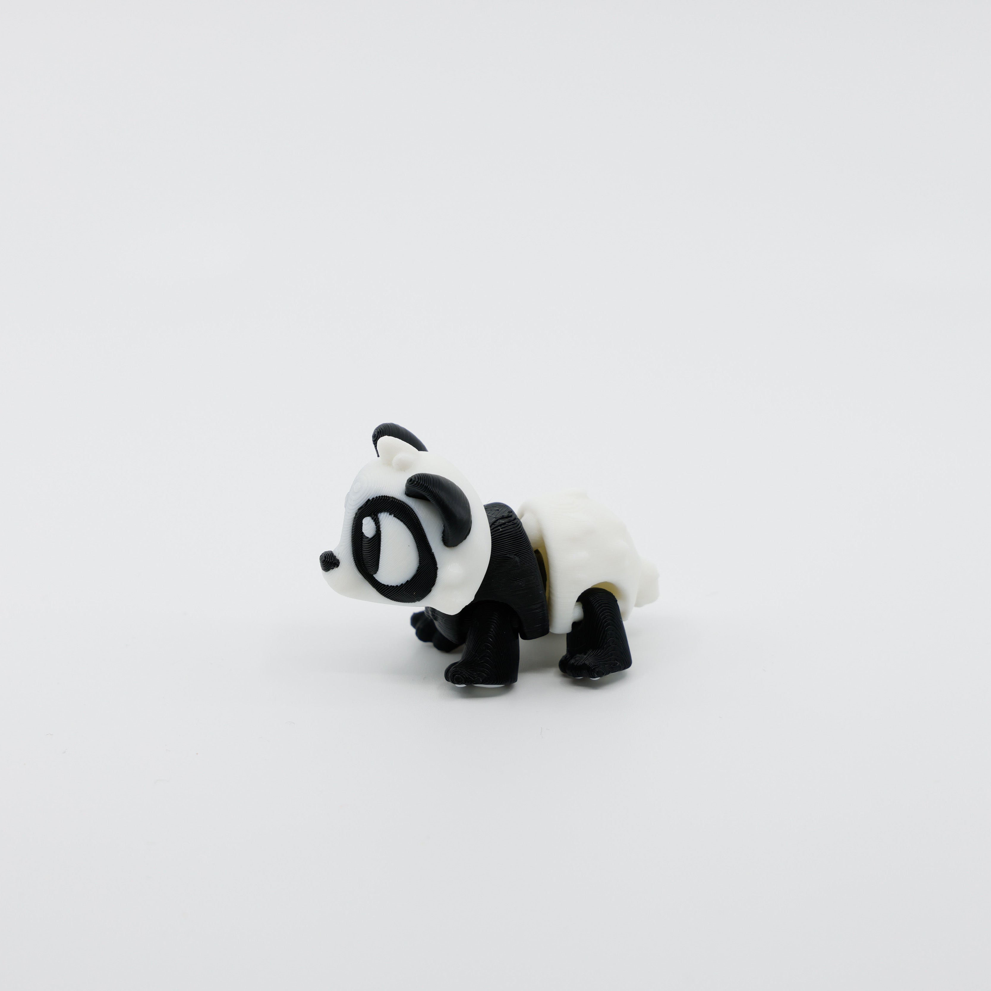 Side profile of articulated panda sensory fidget highlighting curved body segments and soft features