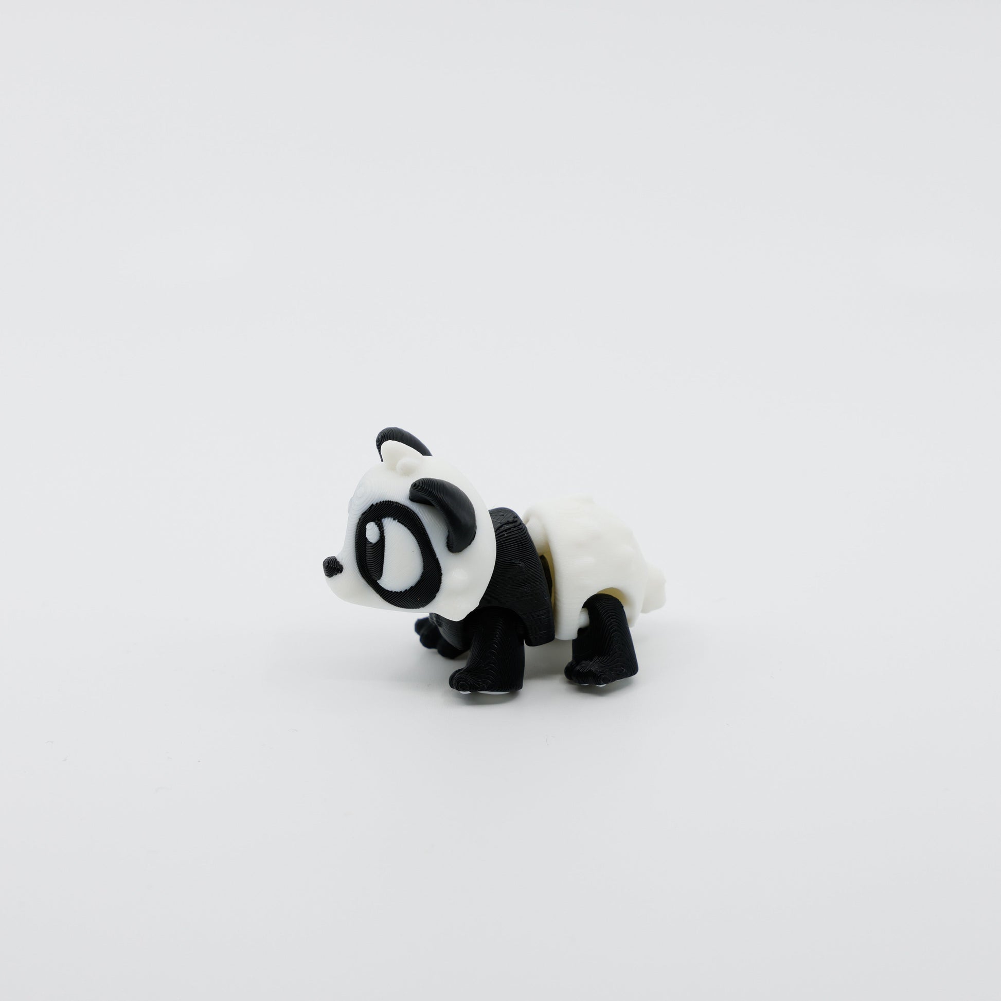 Side profile of articulated panda sensory fidget highlighting curved body segments and soft features
