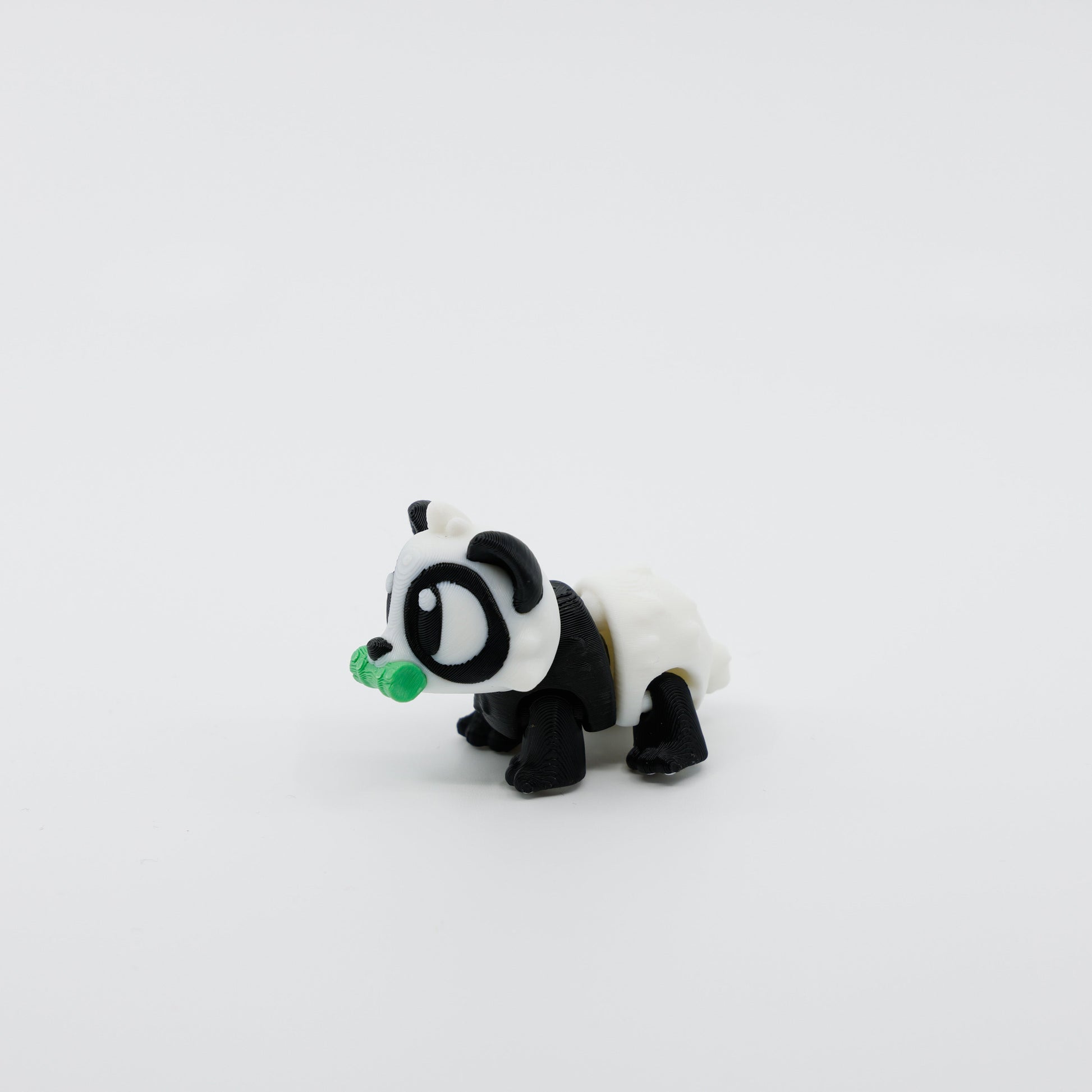 Side profile of articulated panda sensory fidget with bamboo in mouth and smooth body movement
