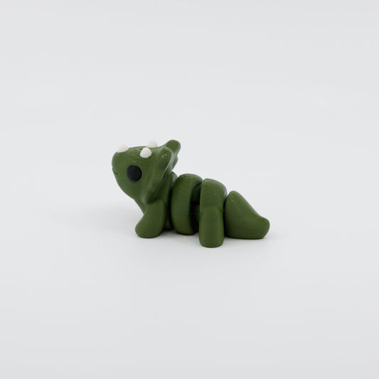 Side profile of articulated triceratops sensory fidget highlighting body segments and distinctive frill