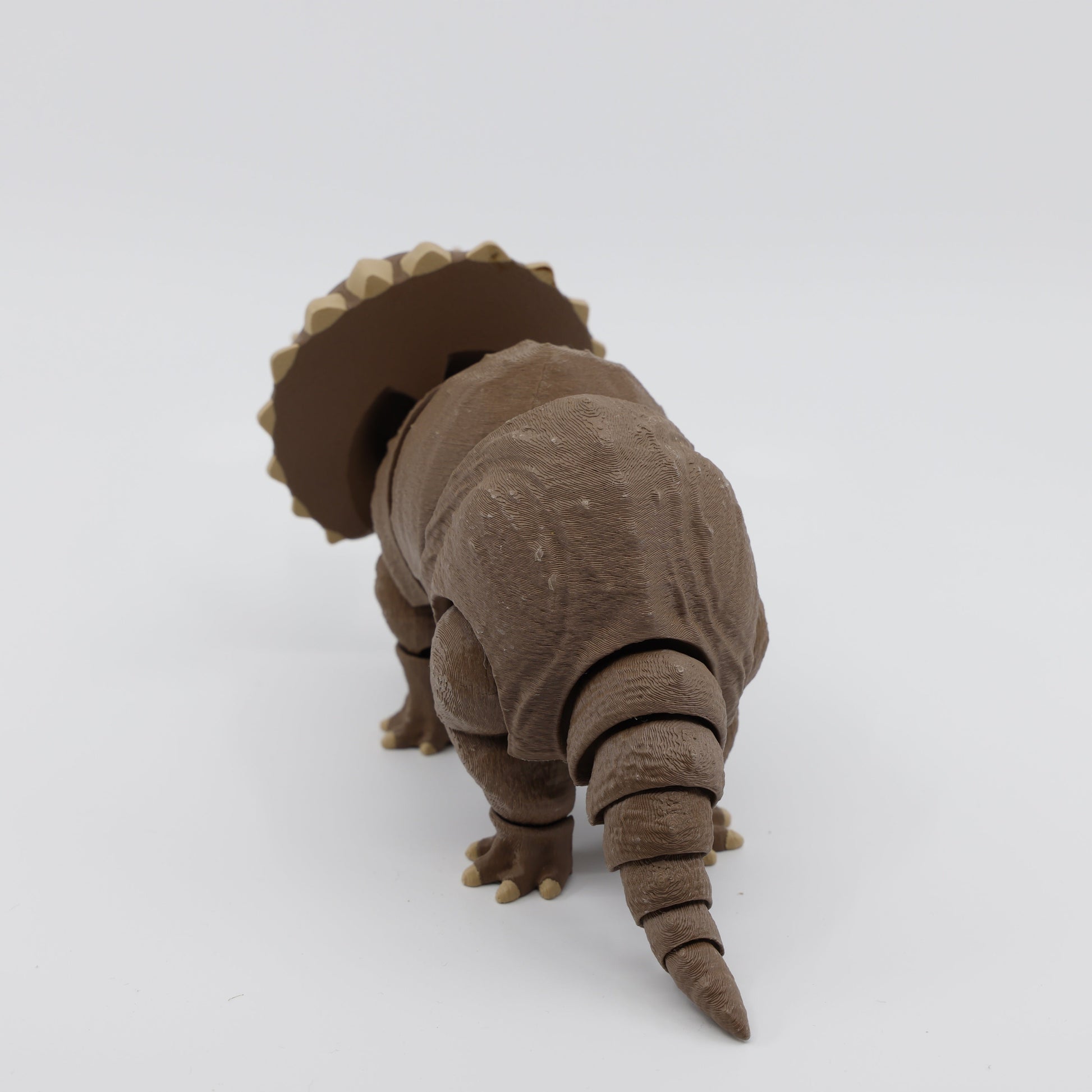 Back view of brown Triceratops fidget – sensory dinosaur toy with tail