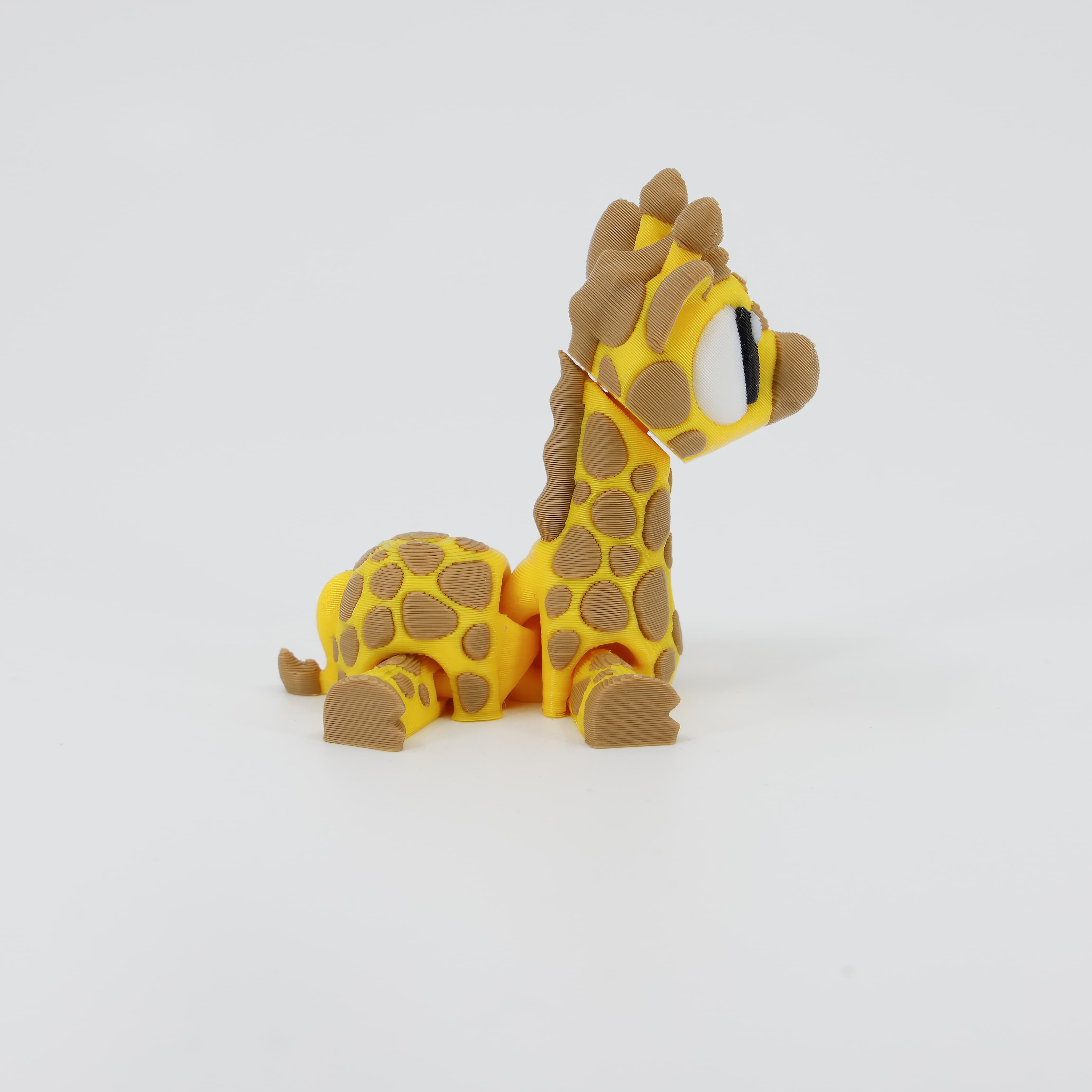 Side view of the flexible 3D printed Giraffe Wiggle Bud. Shows the detailed spot pattern and the articulation points on the neck, body, and flexible legs.