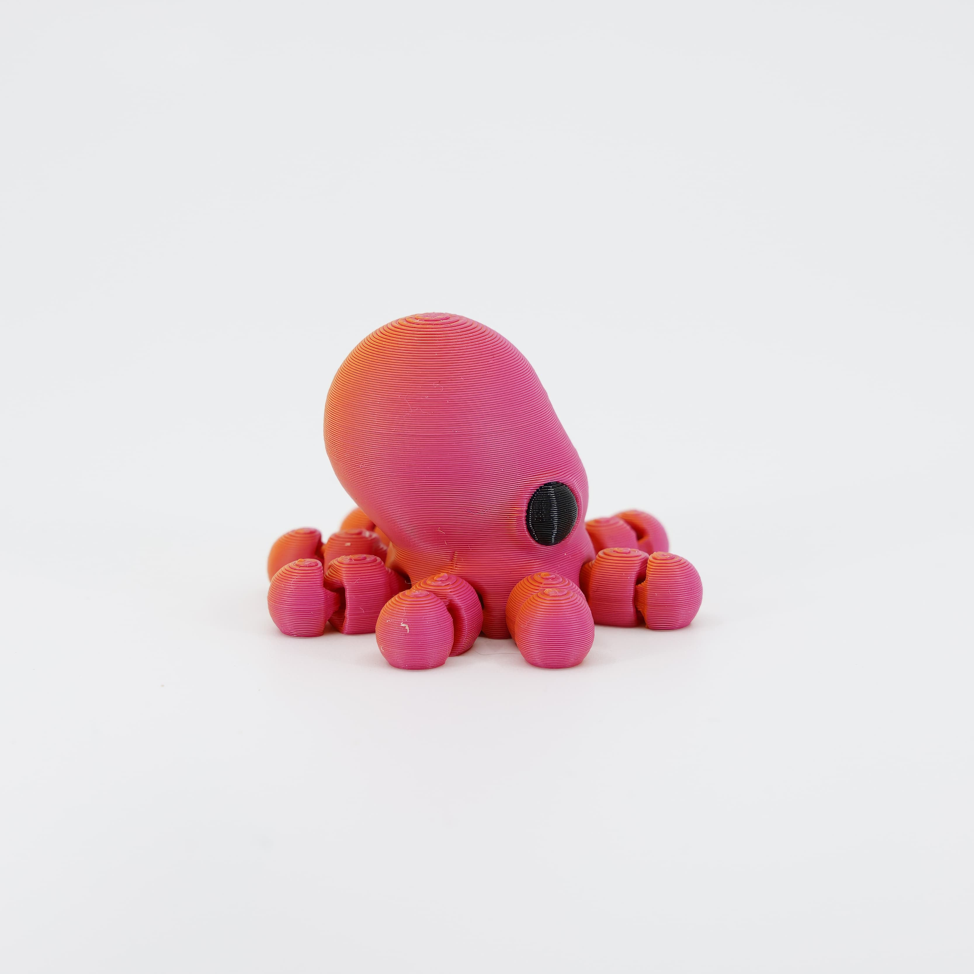 Side view of the flexible 3D printed Octopus Wiggle Bud. Highlights the intricate segmentation of the wiggling tentacles and the smooth texture of the mantle.