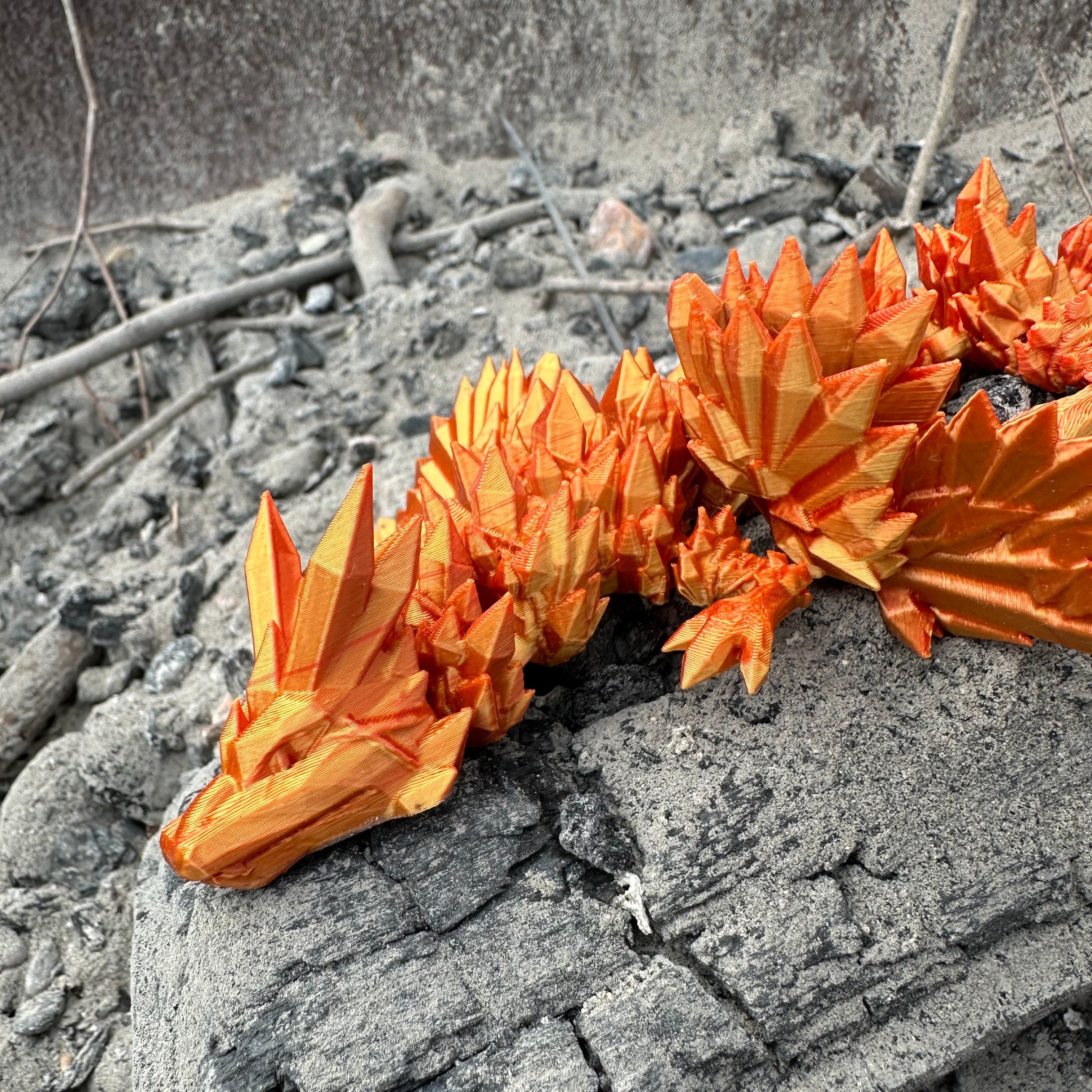 Crystal Winged Dragon Red/Gold laying on charcoal