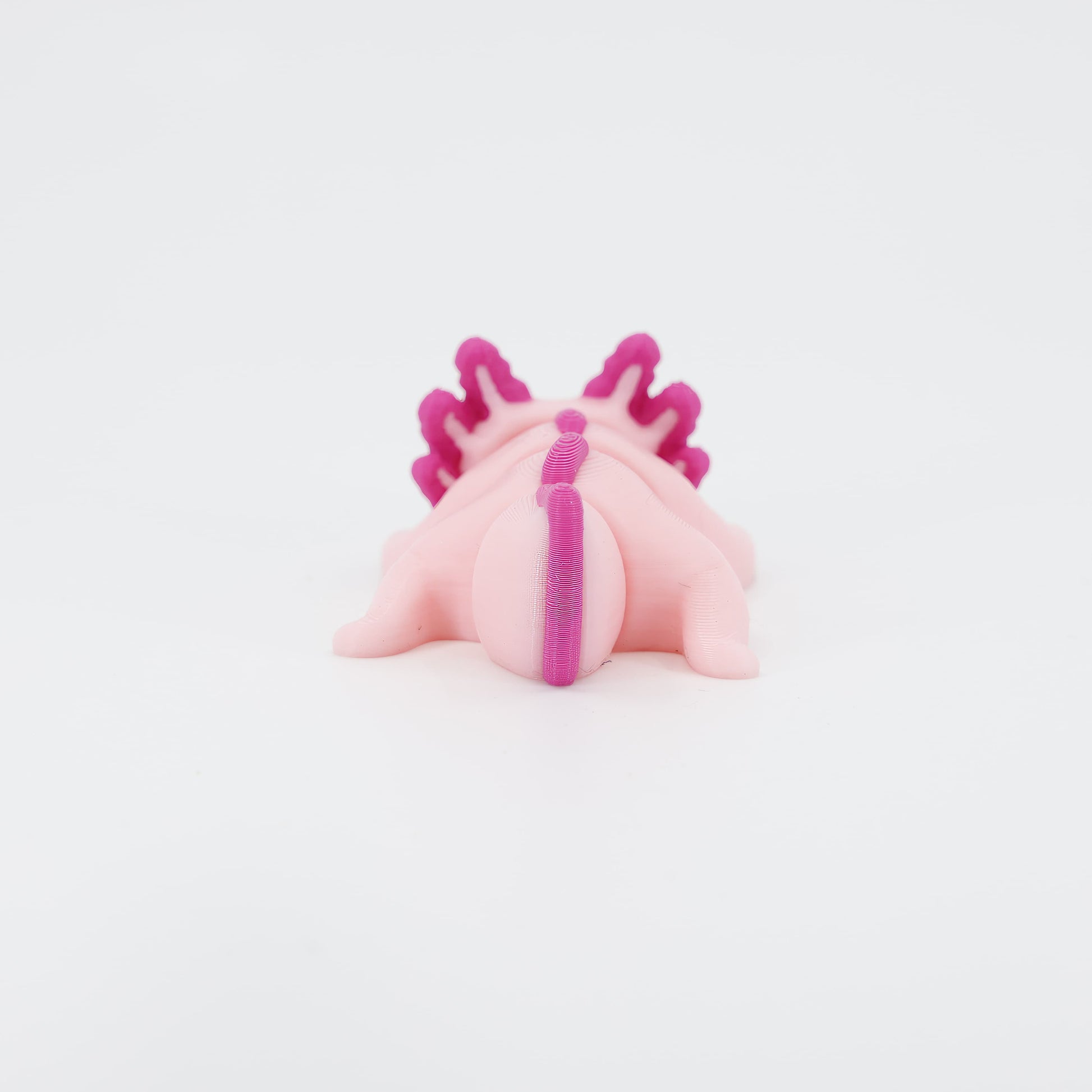 Back view of the miniature 3D printed Axolotl Wiggle Bud toy. Clearly displays the segmented tail design, essential for the fluid, fun wiggle action.