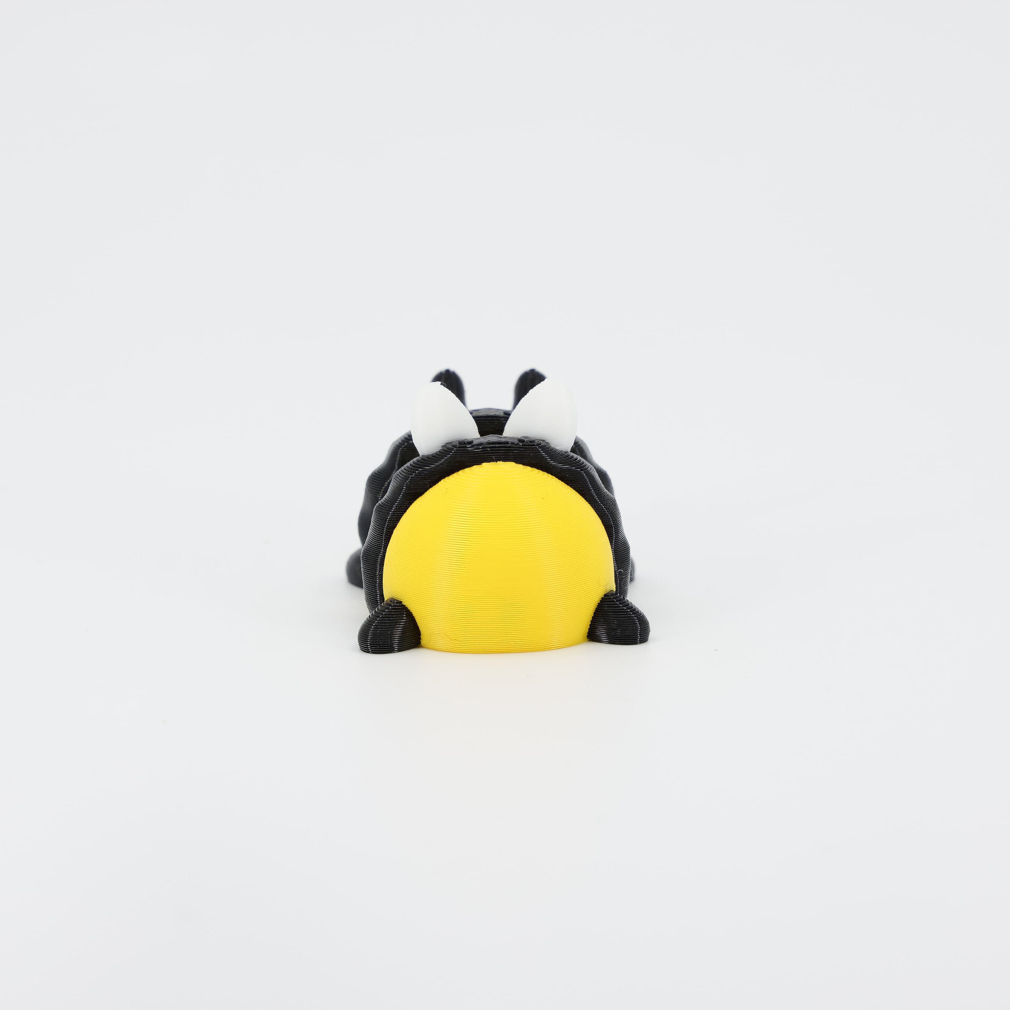 Back view of the miniature 3D printed Bee Wiggle Bud toy. Clearly shows the segmented abdomen and the connecting joints that enable the toy's flexible wiggle action.