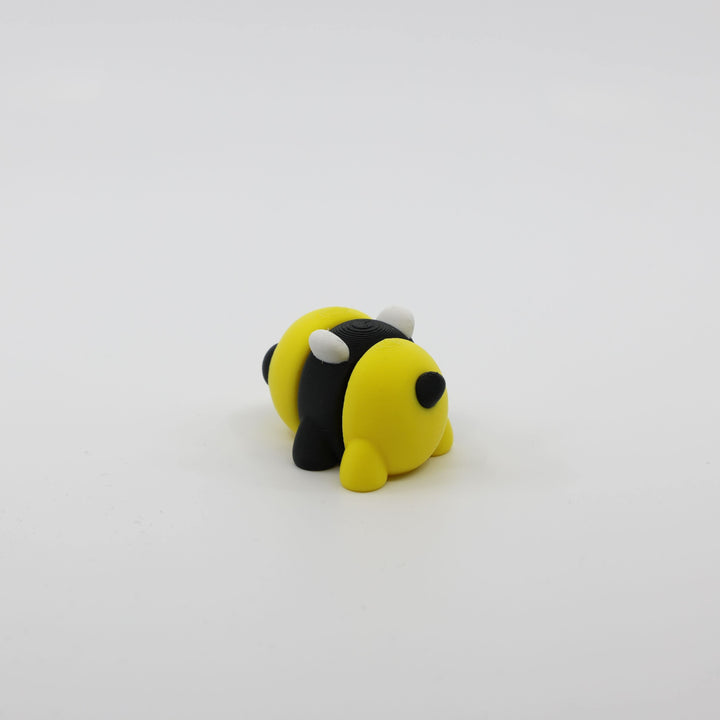 Back view of mini bee fidget showing segmented articulated body and striped design