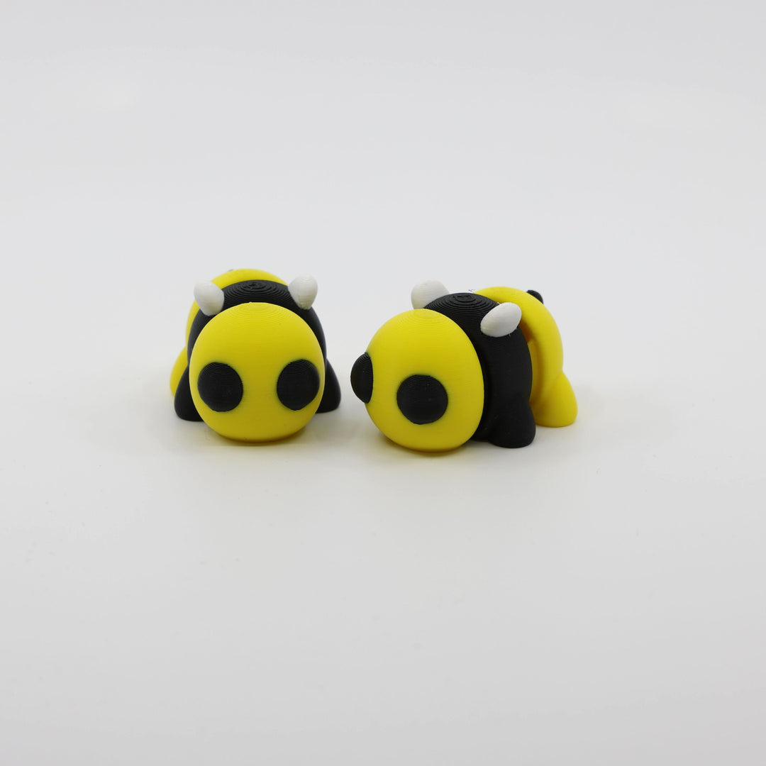 Two articulated mini bee fidgets side by side, showcasing sensory-friendly design and playful details
