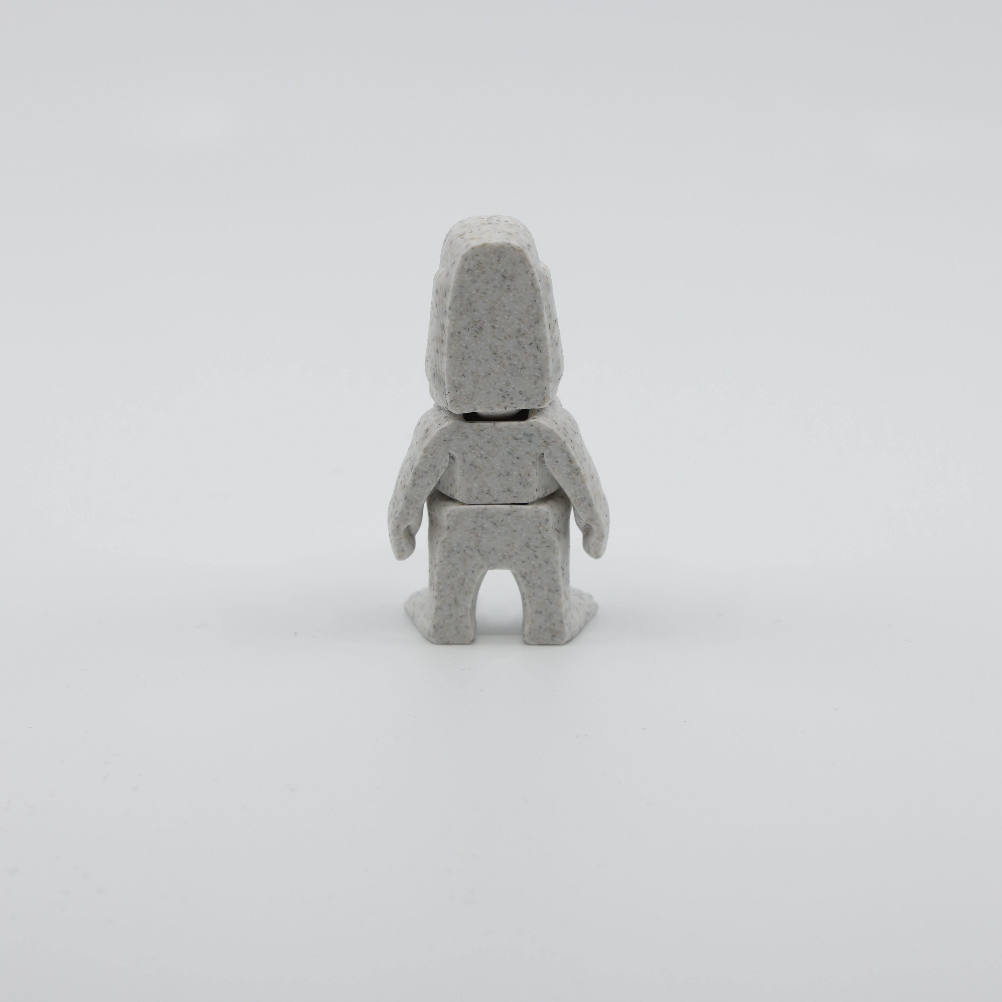 Back view of mini Moai fidget showing segmented articulated body and distinctive head structure