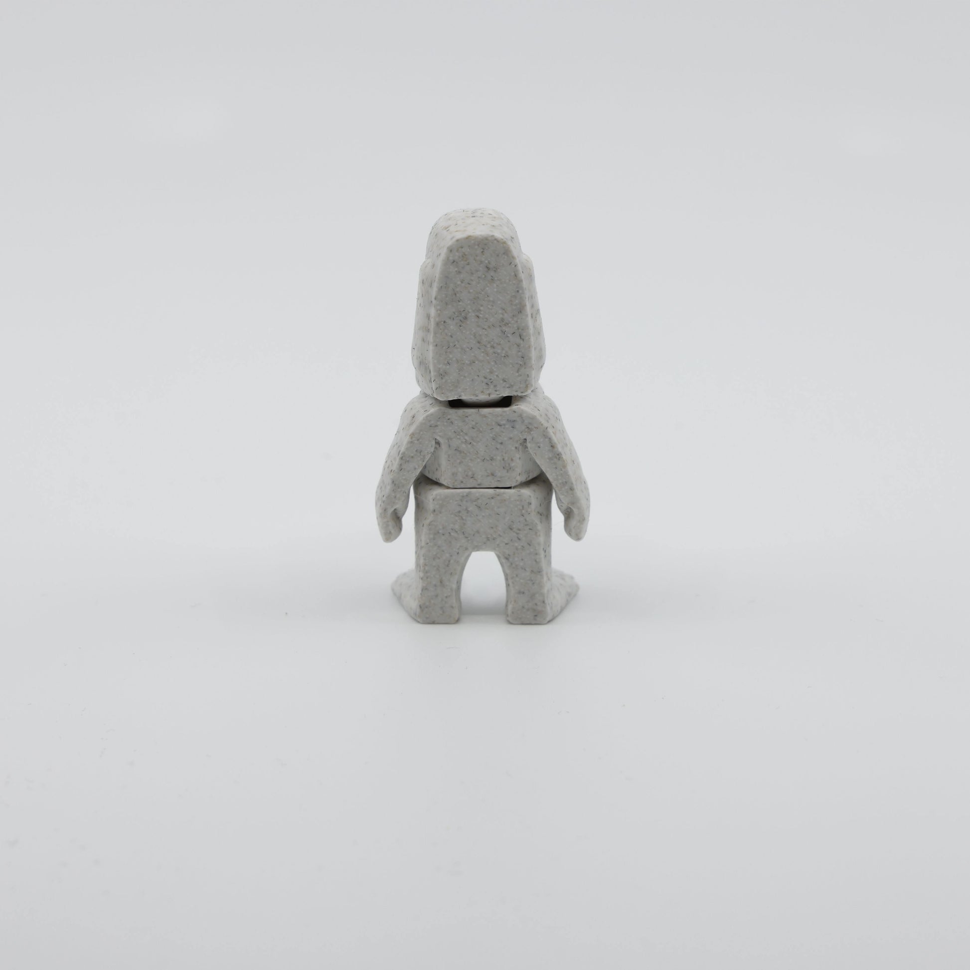 Back view of mini Moai fidget showing segmented articulated body and distinctive head structure