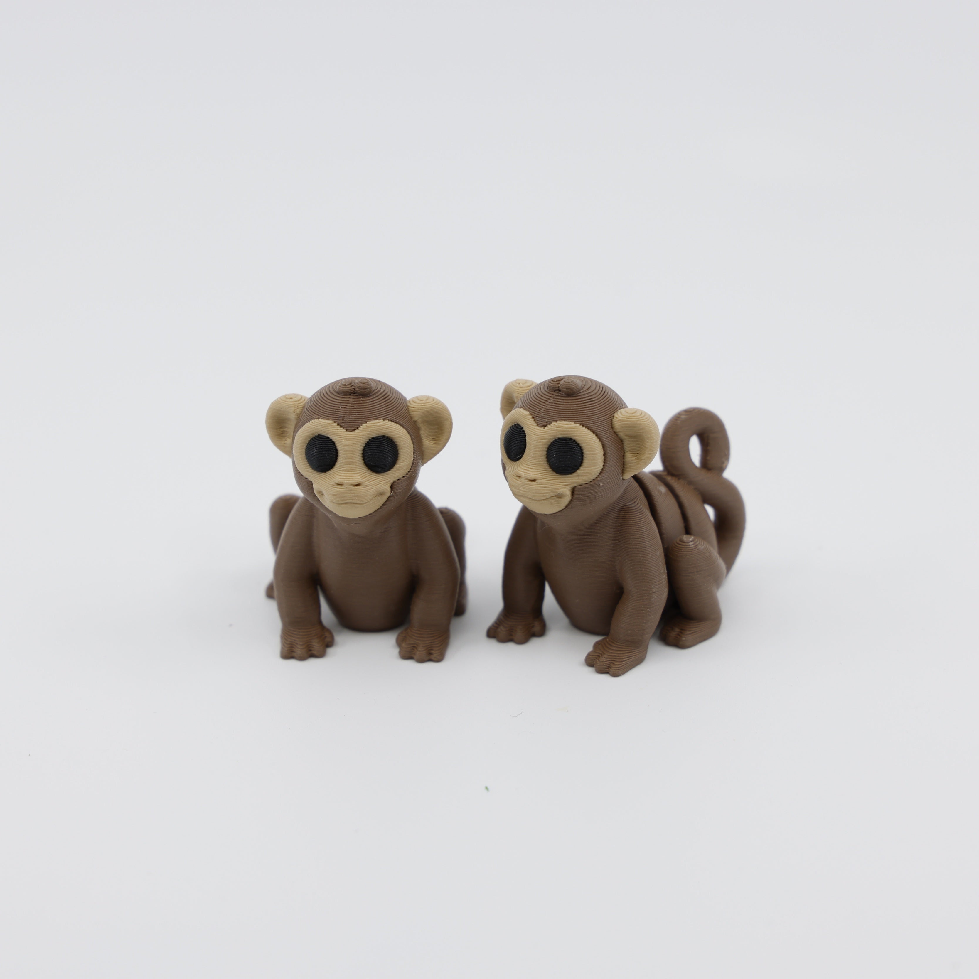 Two articulated monkey fidgets side by side, showing sensory-friendly body movement and poseable design