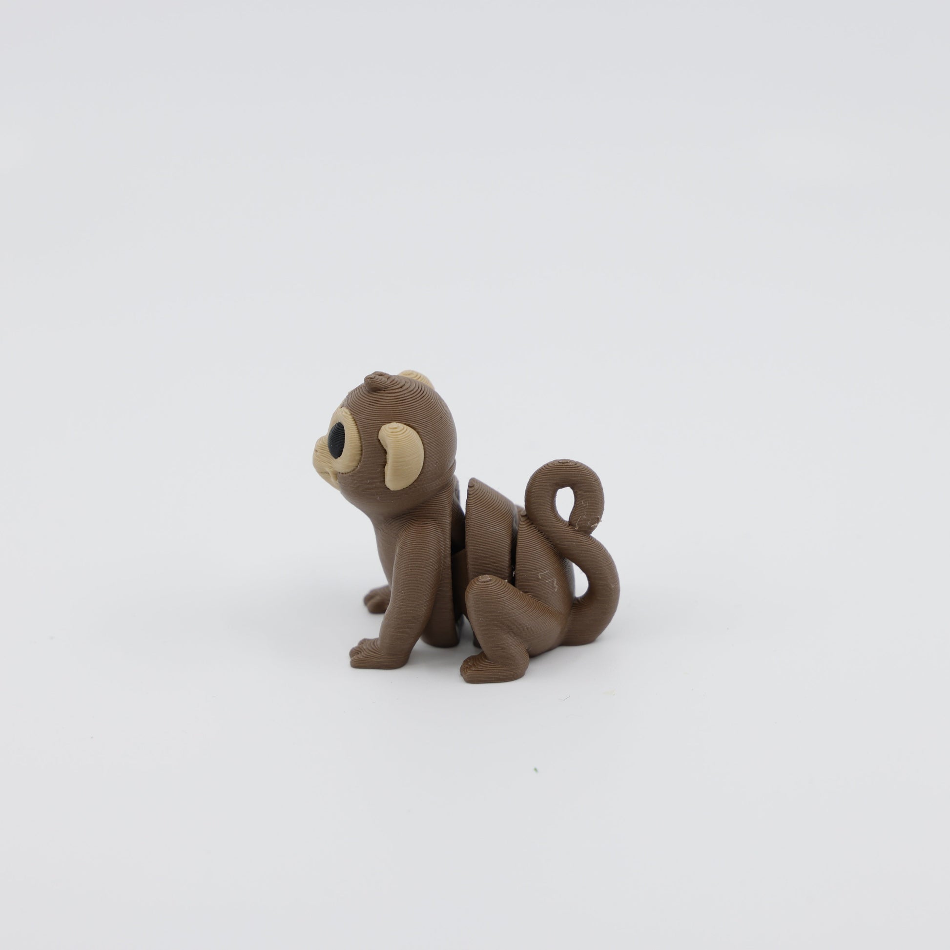 Side profile of articulated monkey sensory fidget highlighting segmented body for tactile play