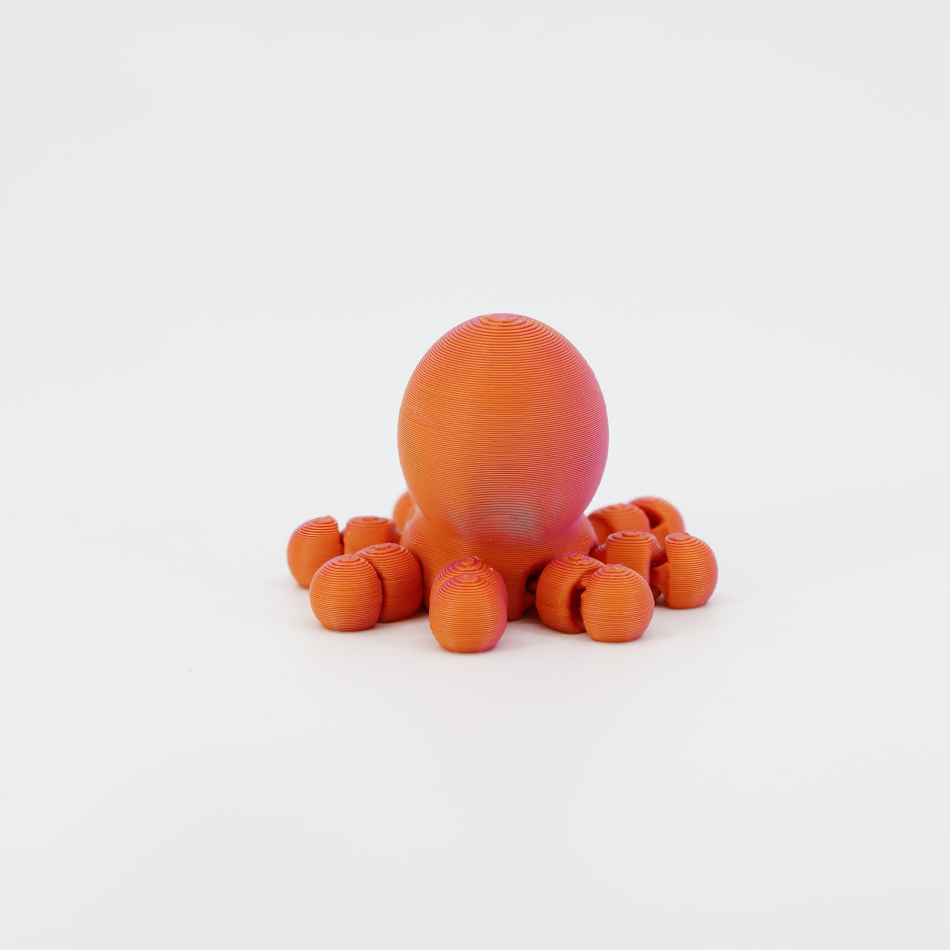 Back view of the miniature 3D printed Octopus Wiggle Bud toy. Clearly shows the rear of the mantle and how the segmented tentacles connect to the body for a full wiggle action.