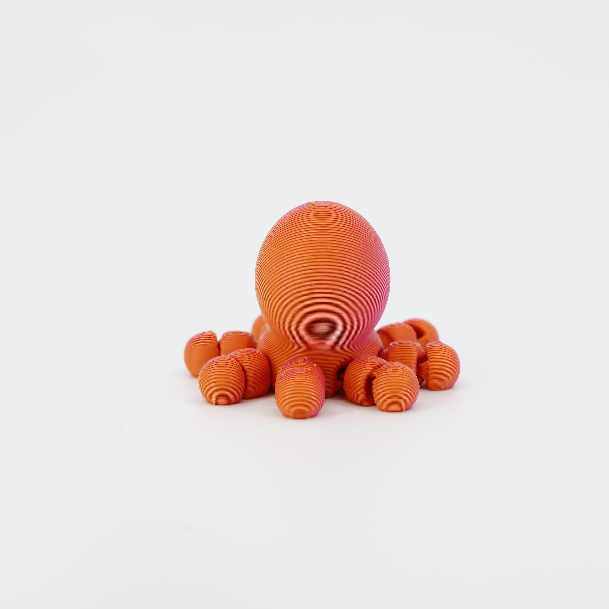 Back view of the miniature 3D printed Octopus Wiggle Bud toy. Clearly shows the rear of the mantle and how the segmented tentacles connect to the body for a full wiggle action.