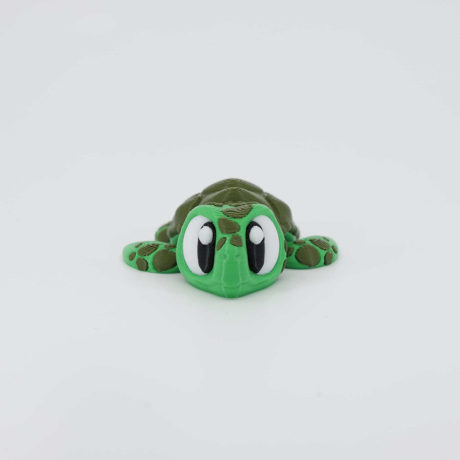 Front view of the Mini Sea Turtle Wiggle Bud fidget toy. Highlights the cute head and articulated flippers created via 3D printing.
