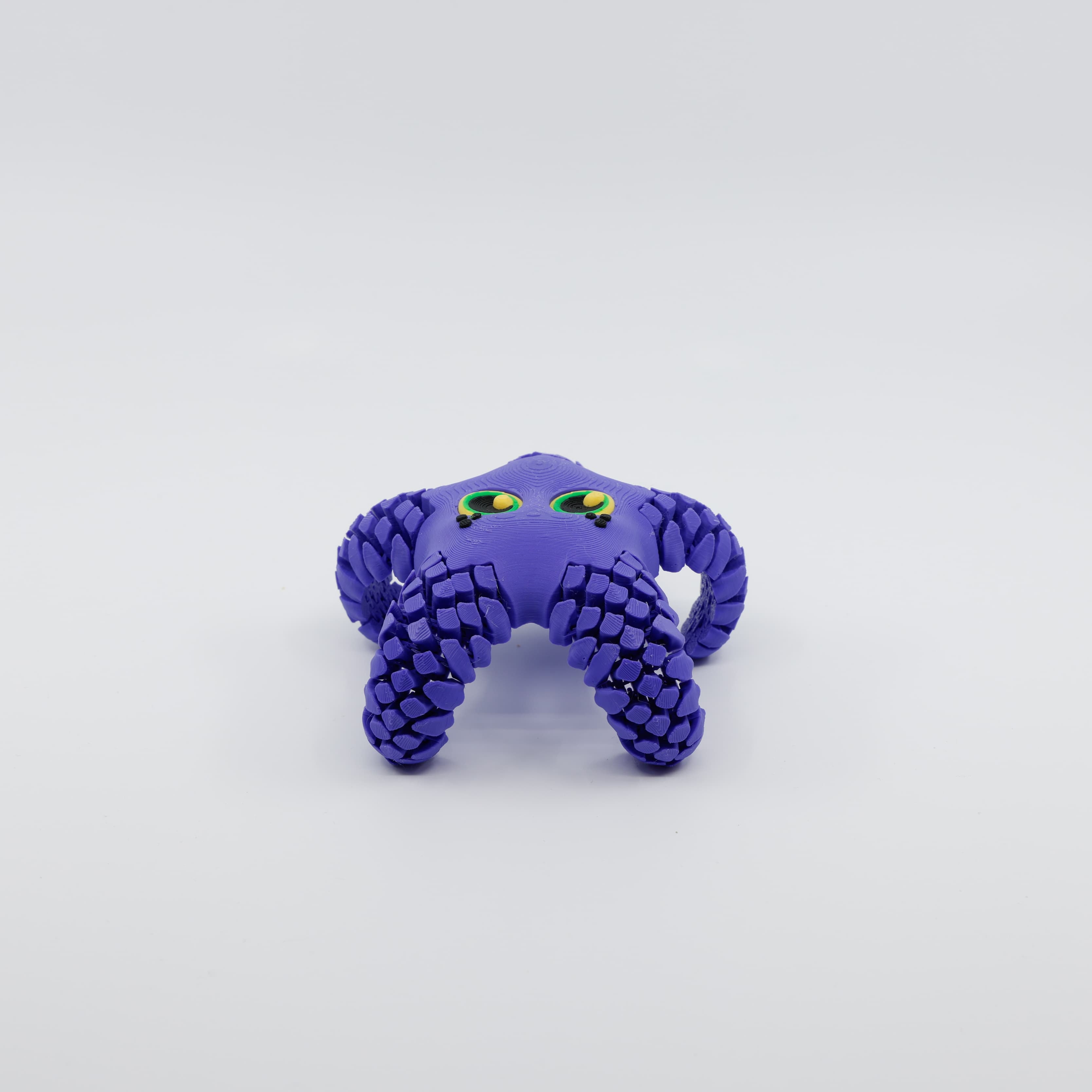 Front view of 3D printed flexi starfish fidget with articulated arms tucked under body in purple