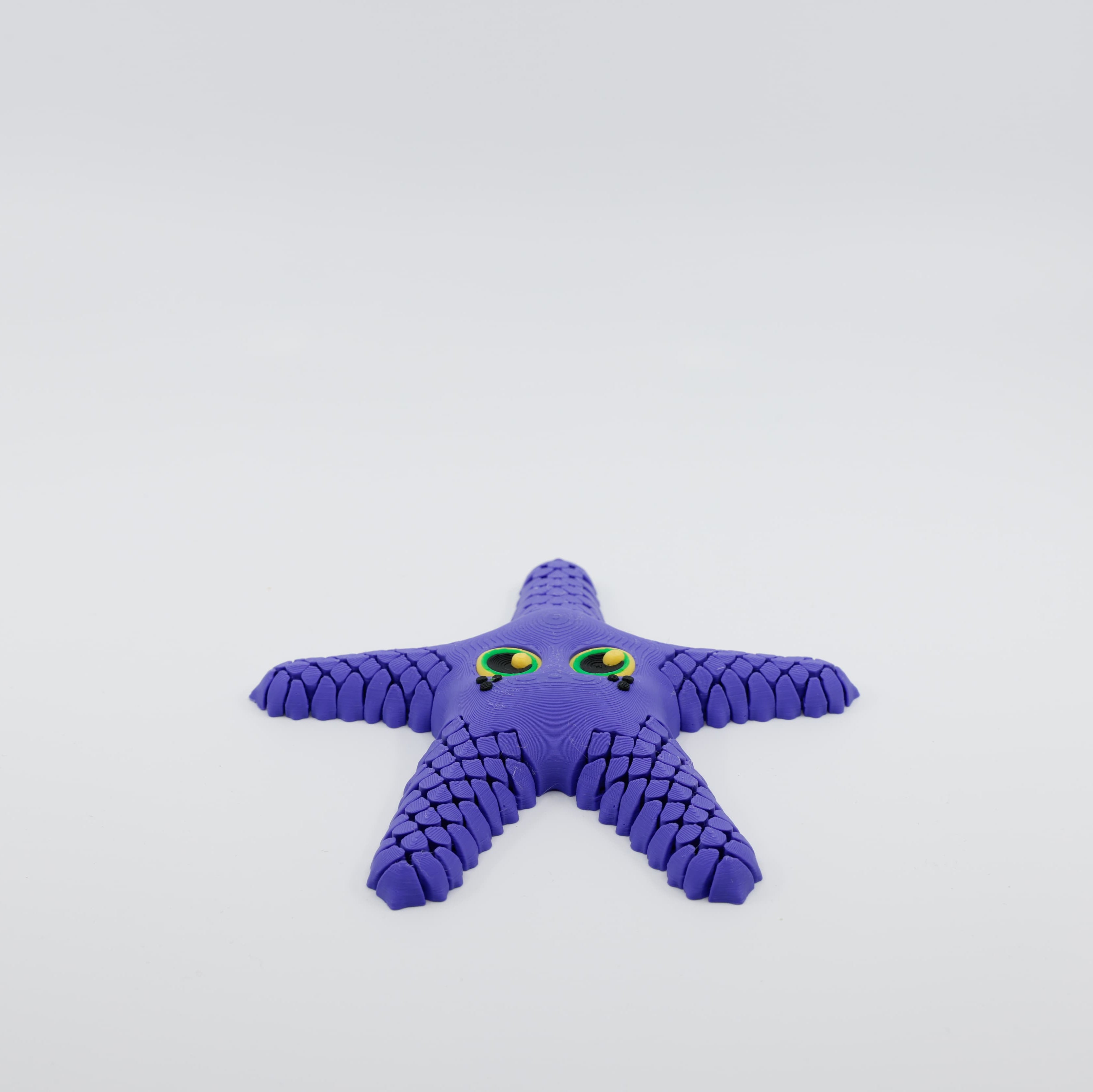 Front view of 3D printed flexi starfish fidget with articulated arms in purple