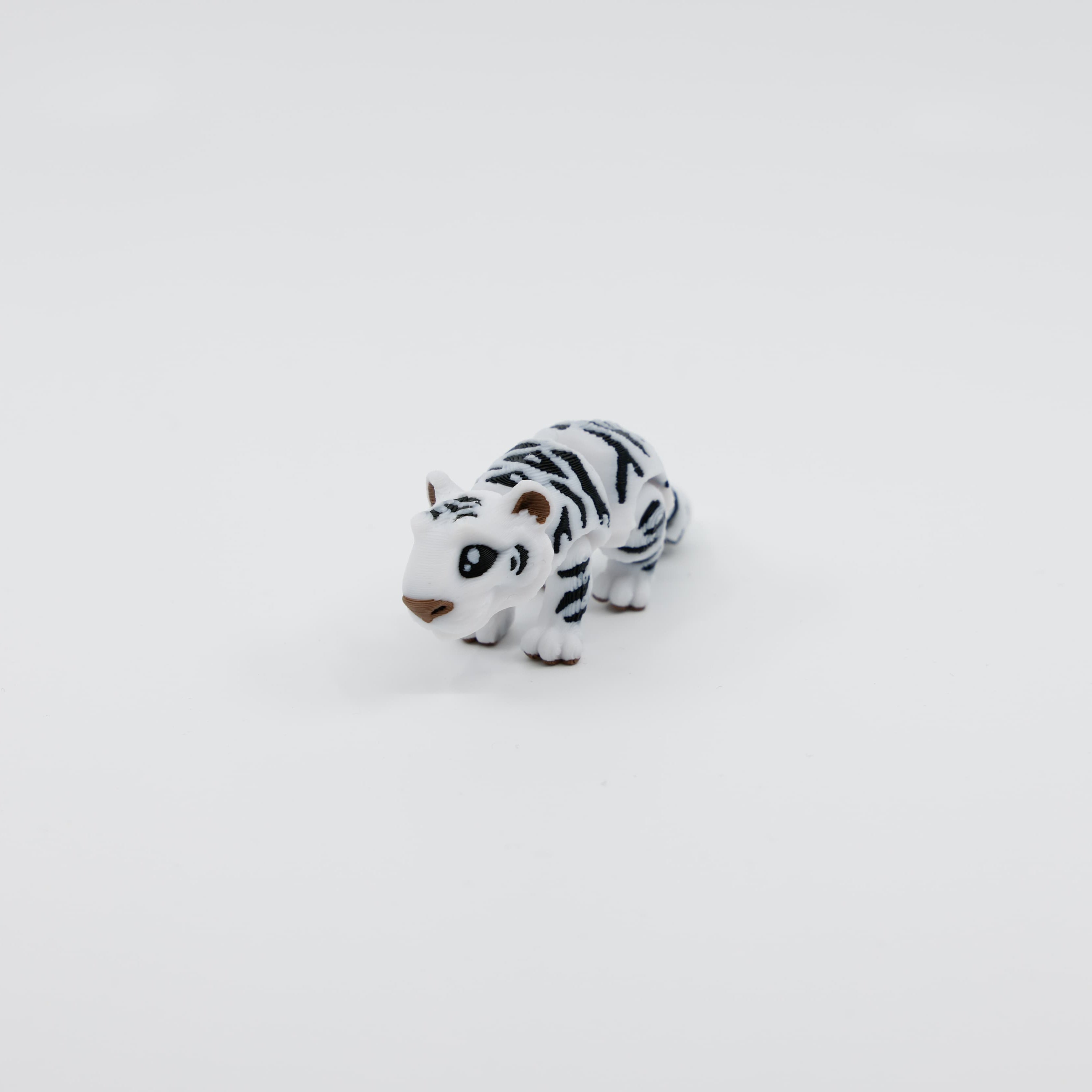 Front view of mini snow tiger fidget toy with articulated legs