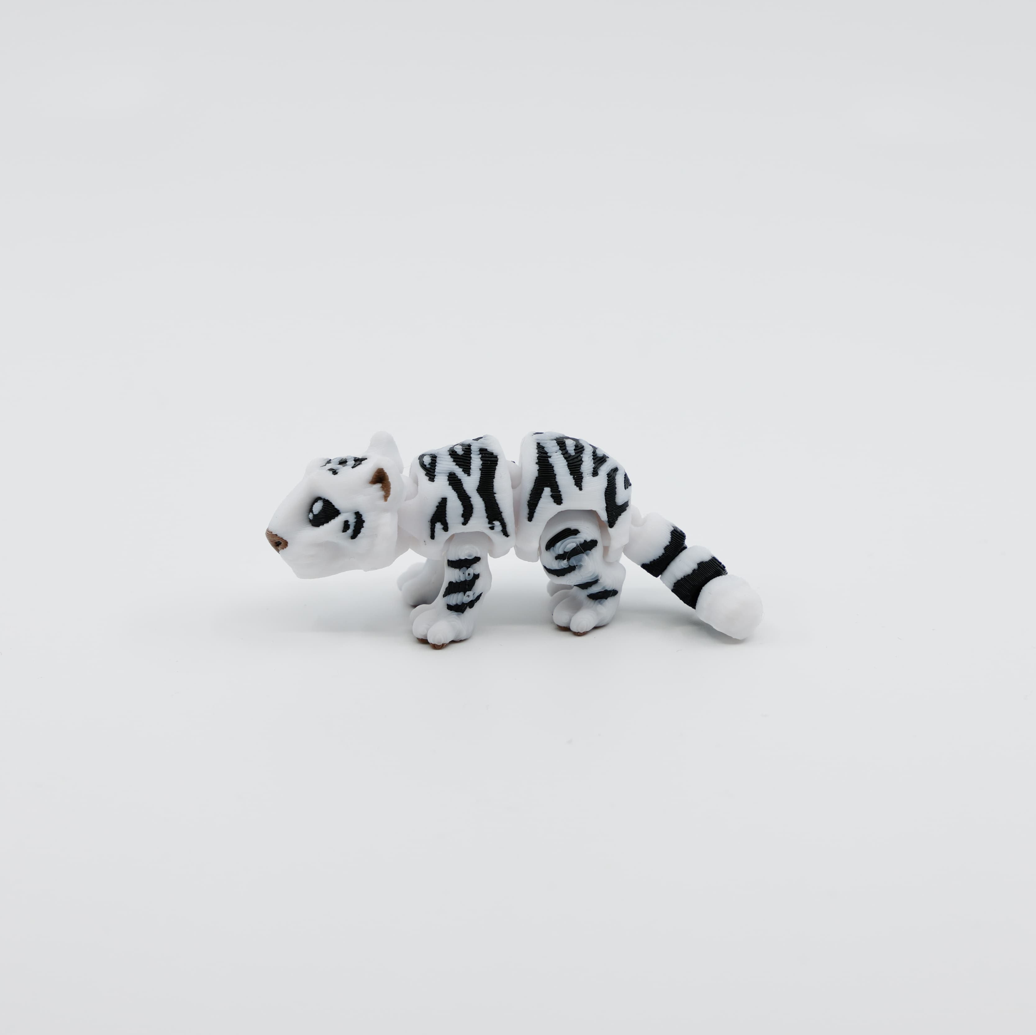Side view of articulated 3D printed snow tiger fidget toy