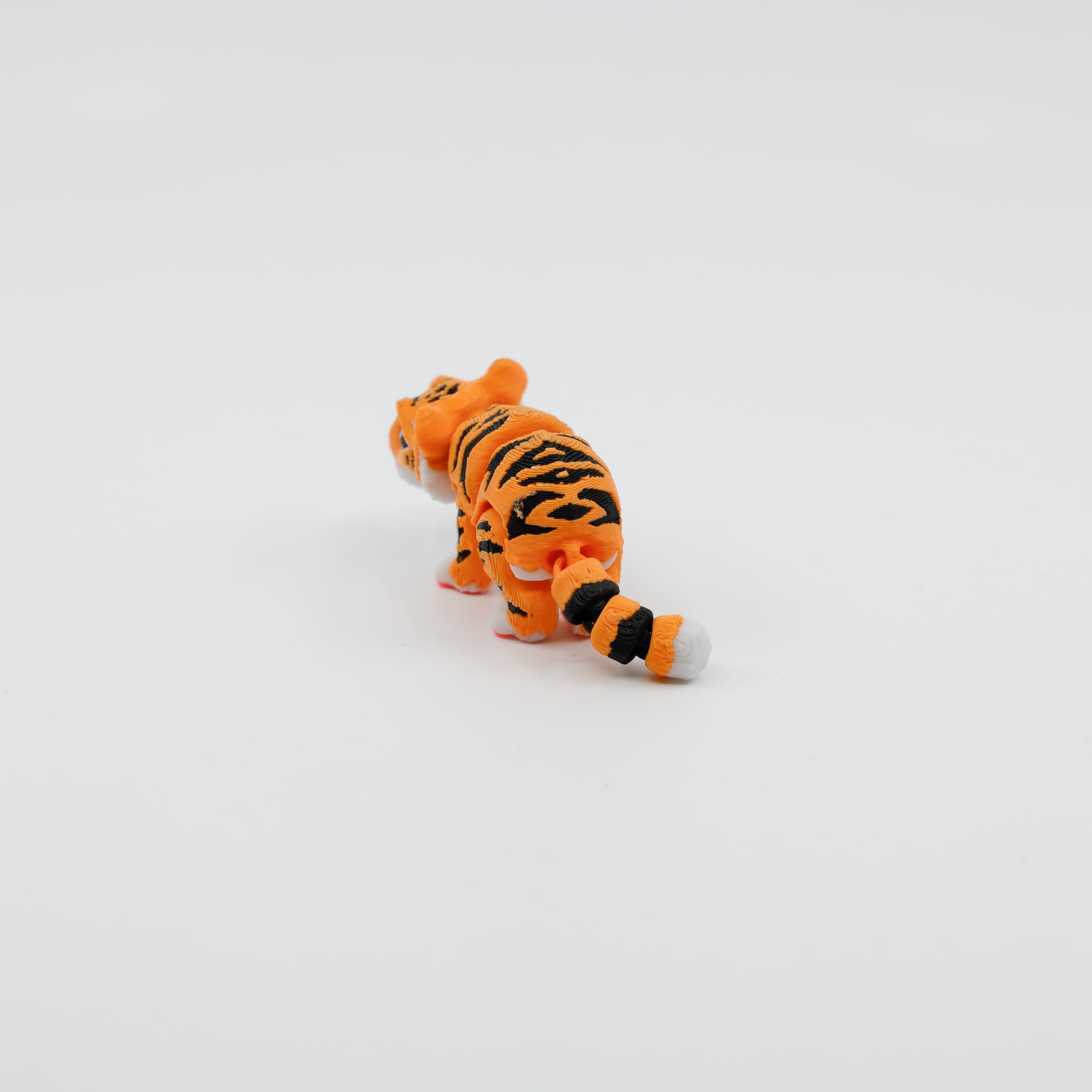 Back view of articulated mini tiger toy showing segmented tail