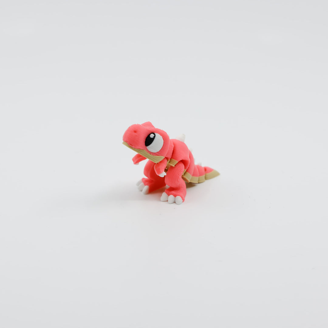 Front view of 3D printed mini T. rex fidget toy with articulated body in pink
